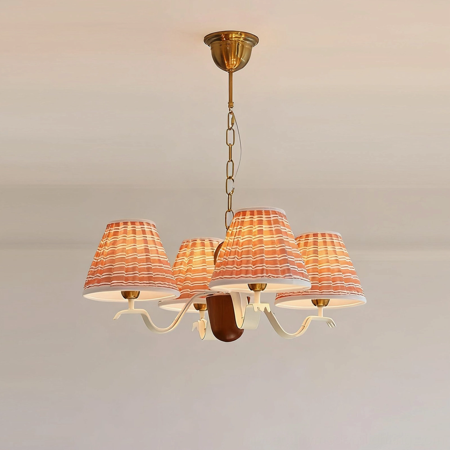 Coral-red checkered pleated ruffled lamp shades with curved white arms on warm wall background