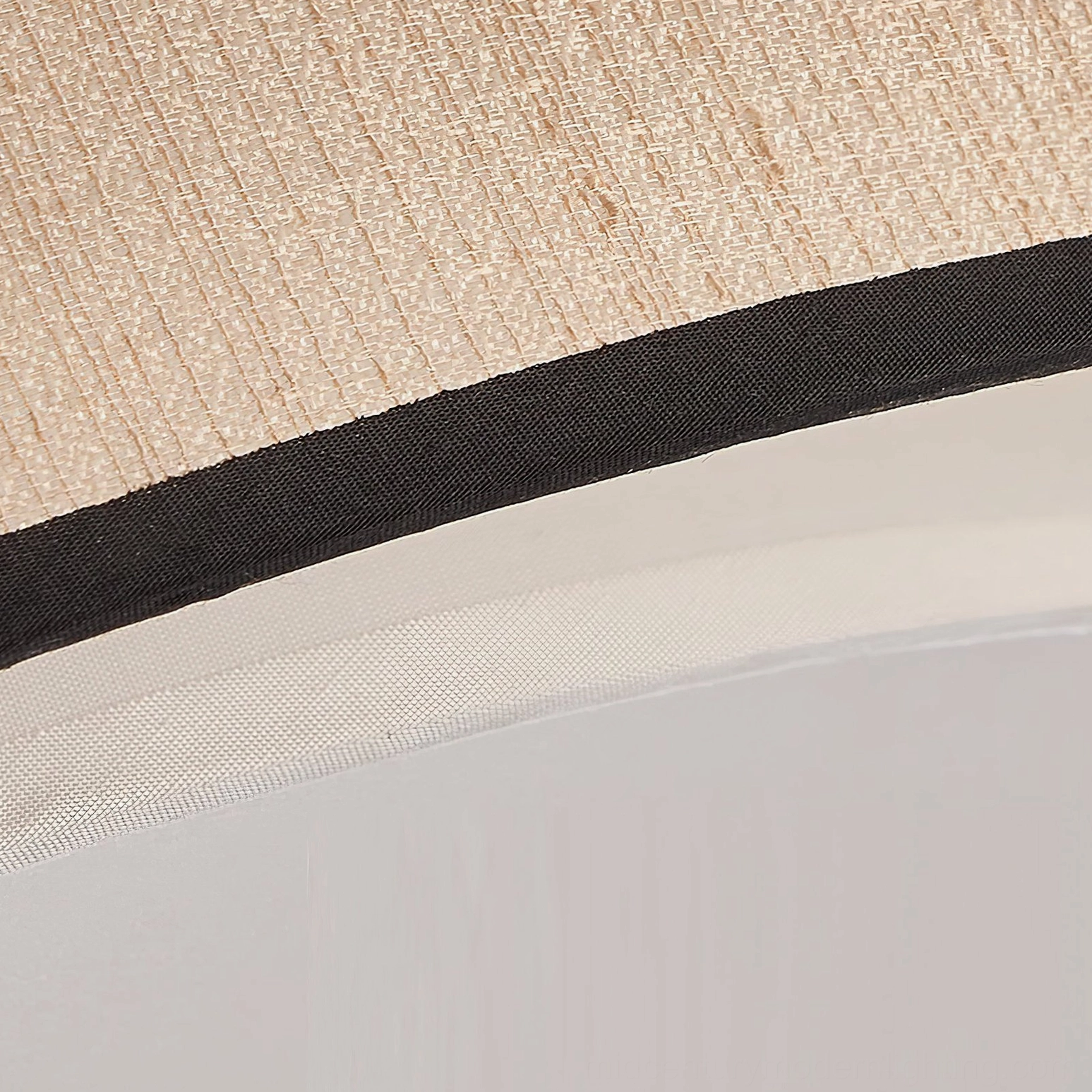 Macro detail shot of Duolla ceiling light edge showing woven beige jute fiber, black border trim, and precision construction