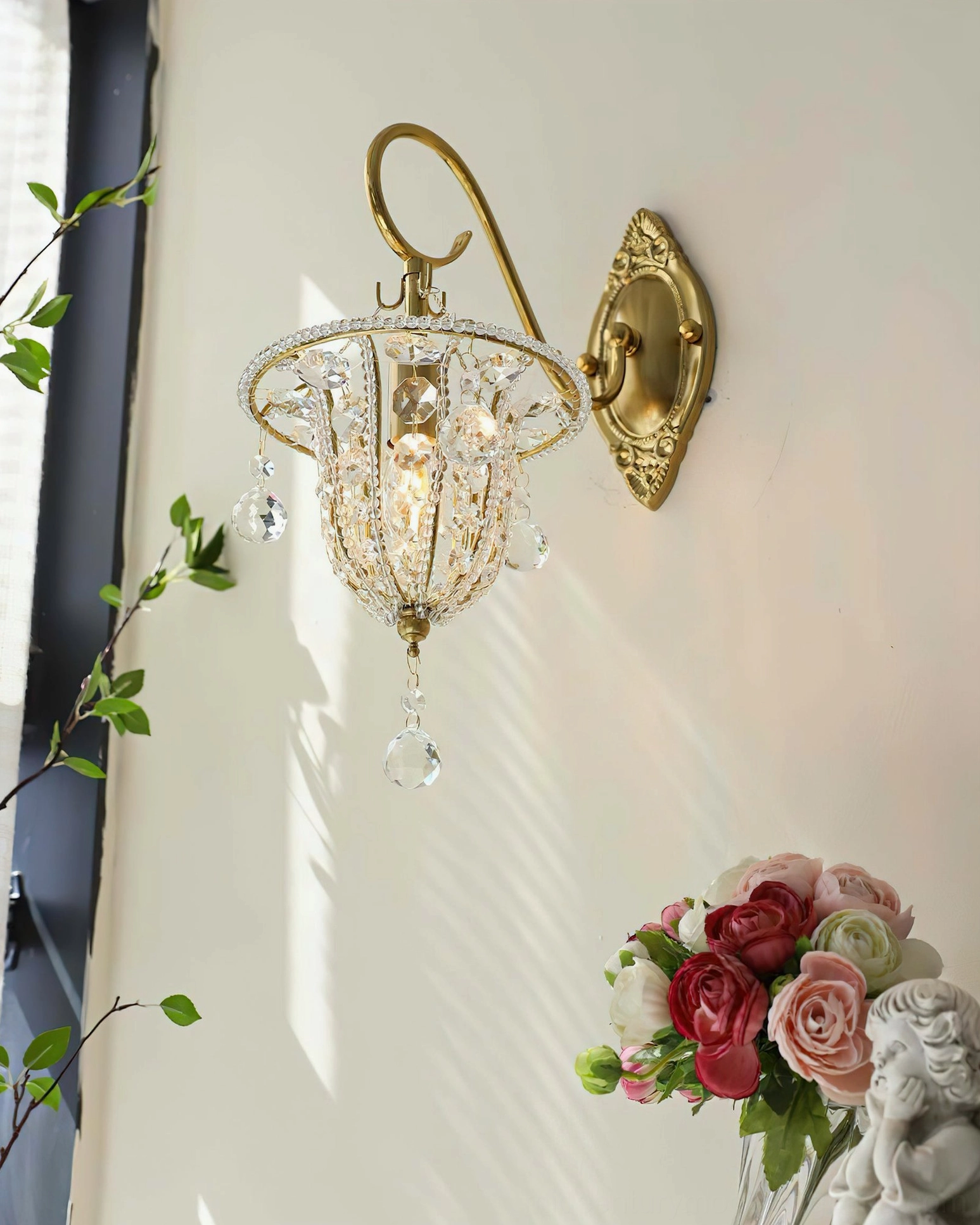 Close-up detail of Eilers crystal sconce showing beaded crystal lampshade and curved gold brass mounting frame against soft background