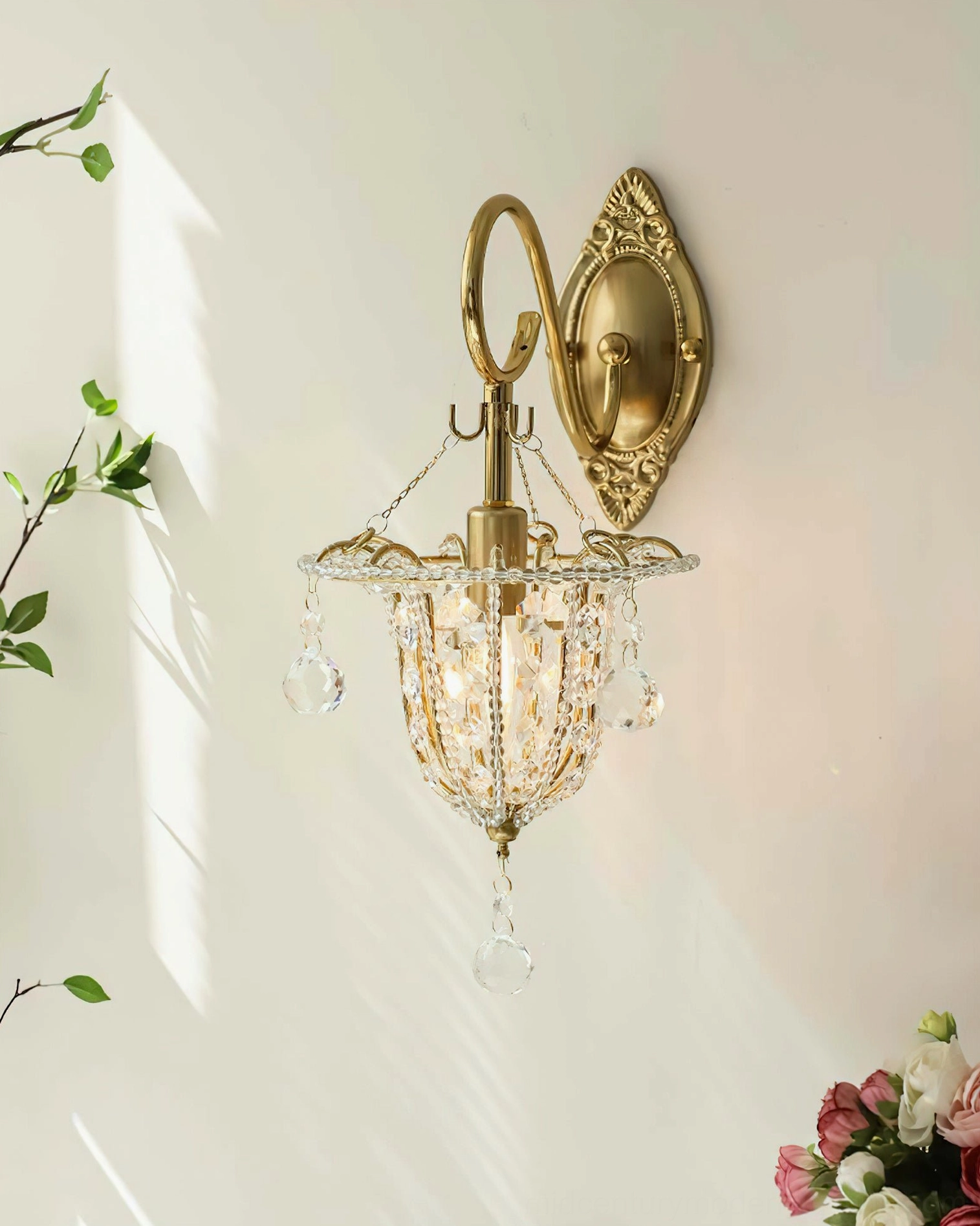 Eilers gold brass crystal wall sconce in interior setting, displaying sophisticated jewelry-like glow and beaded crystal shade elements in ambient lighting