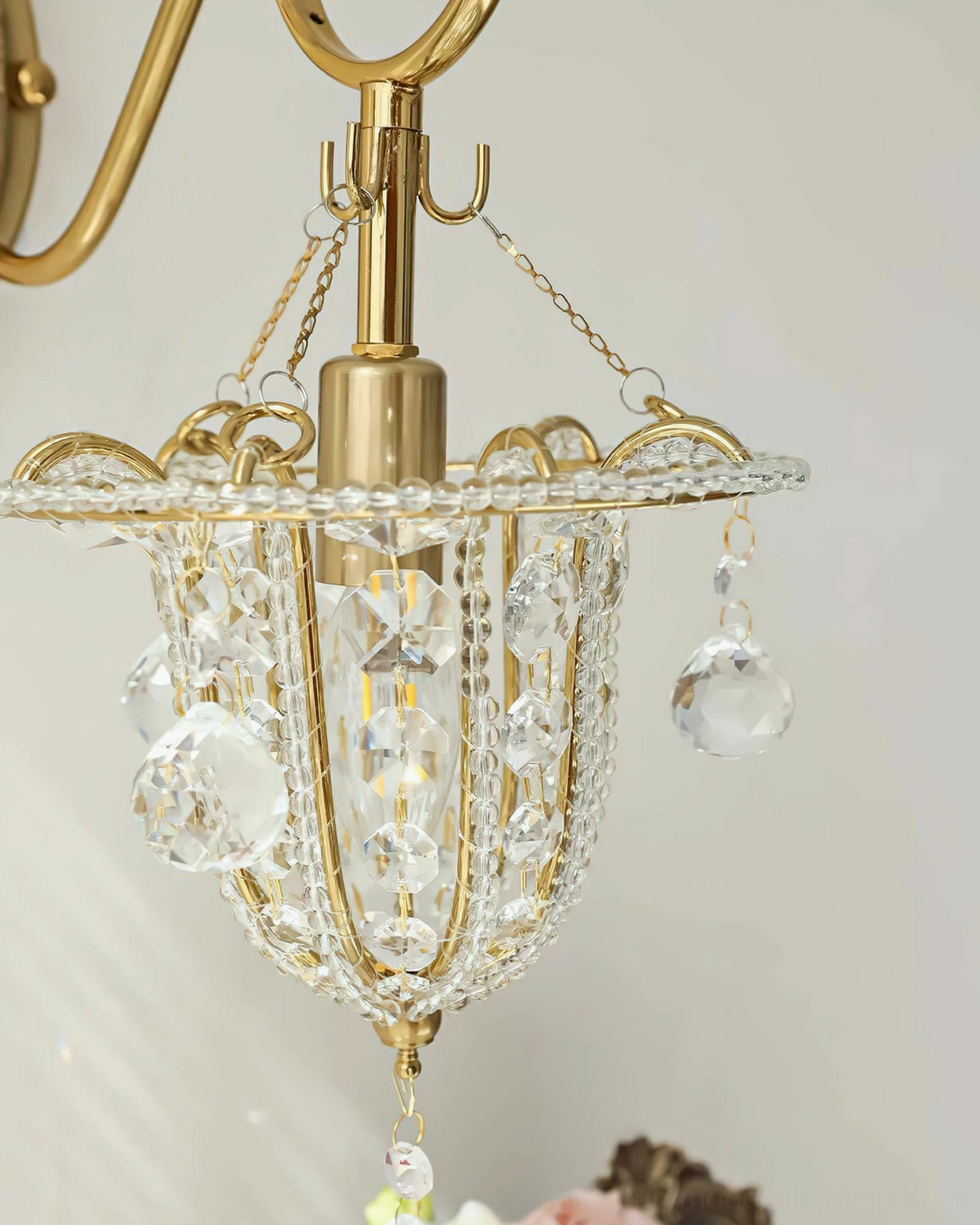 Detailed view of Eilers crystal wall sconce showing polished brass finish, ornate brass mounting, and sparkling crystal beads on white background