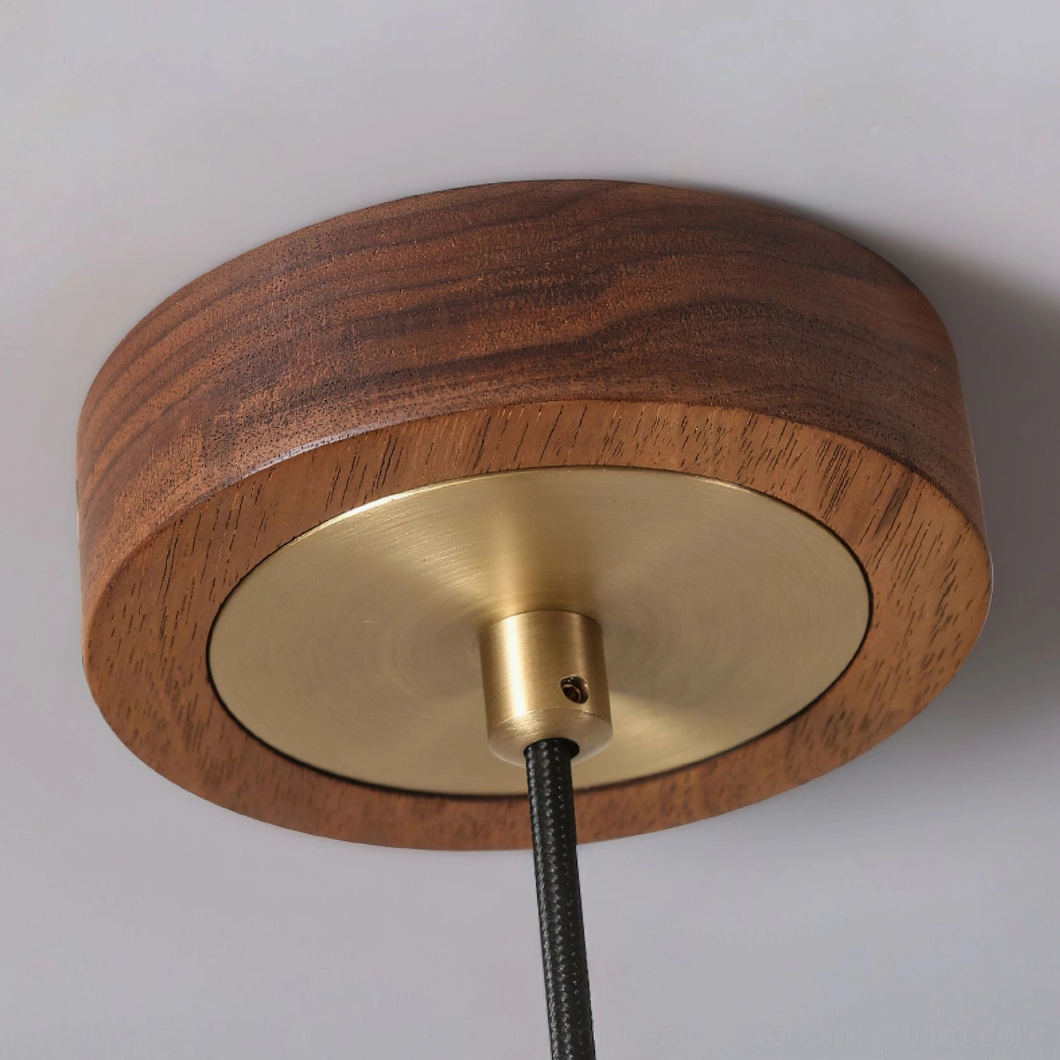 Ceiling mount base of Elara pendant with walnut wood ring, brass metal plate, and black cord
