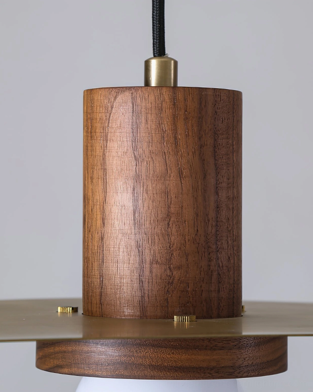 Elara pendant lamp components close-up showing walnut wood cylinder and brass metal accents