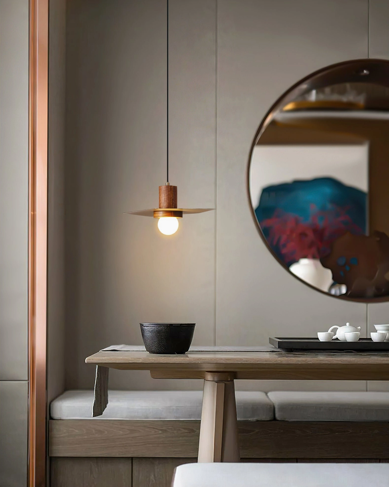 Single Elara pendant lamp in dining nook with round mirror and warm walnut finish