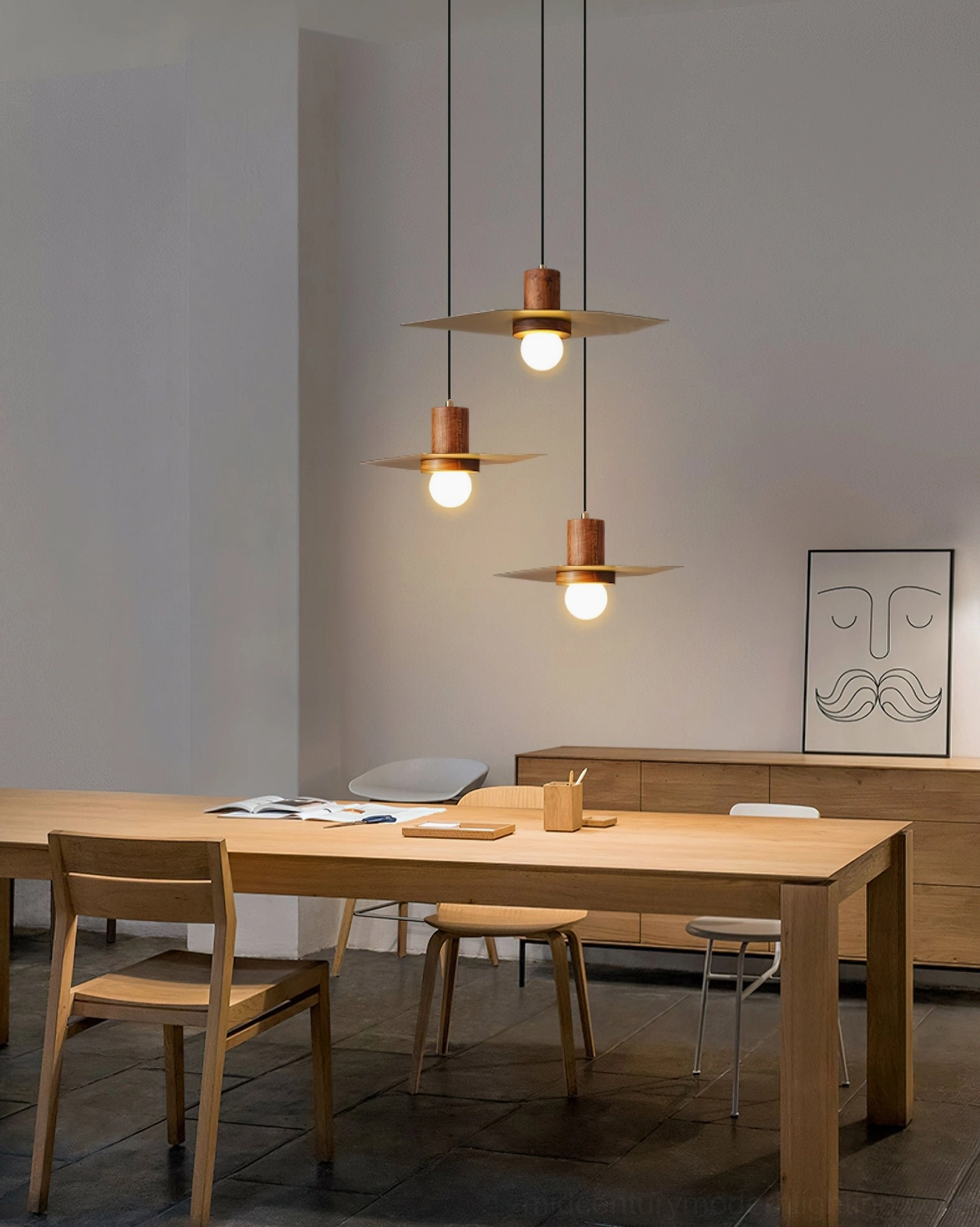 Set of three Elara walnut and brass pendant lights in modern dining lounge with neutral tones