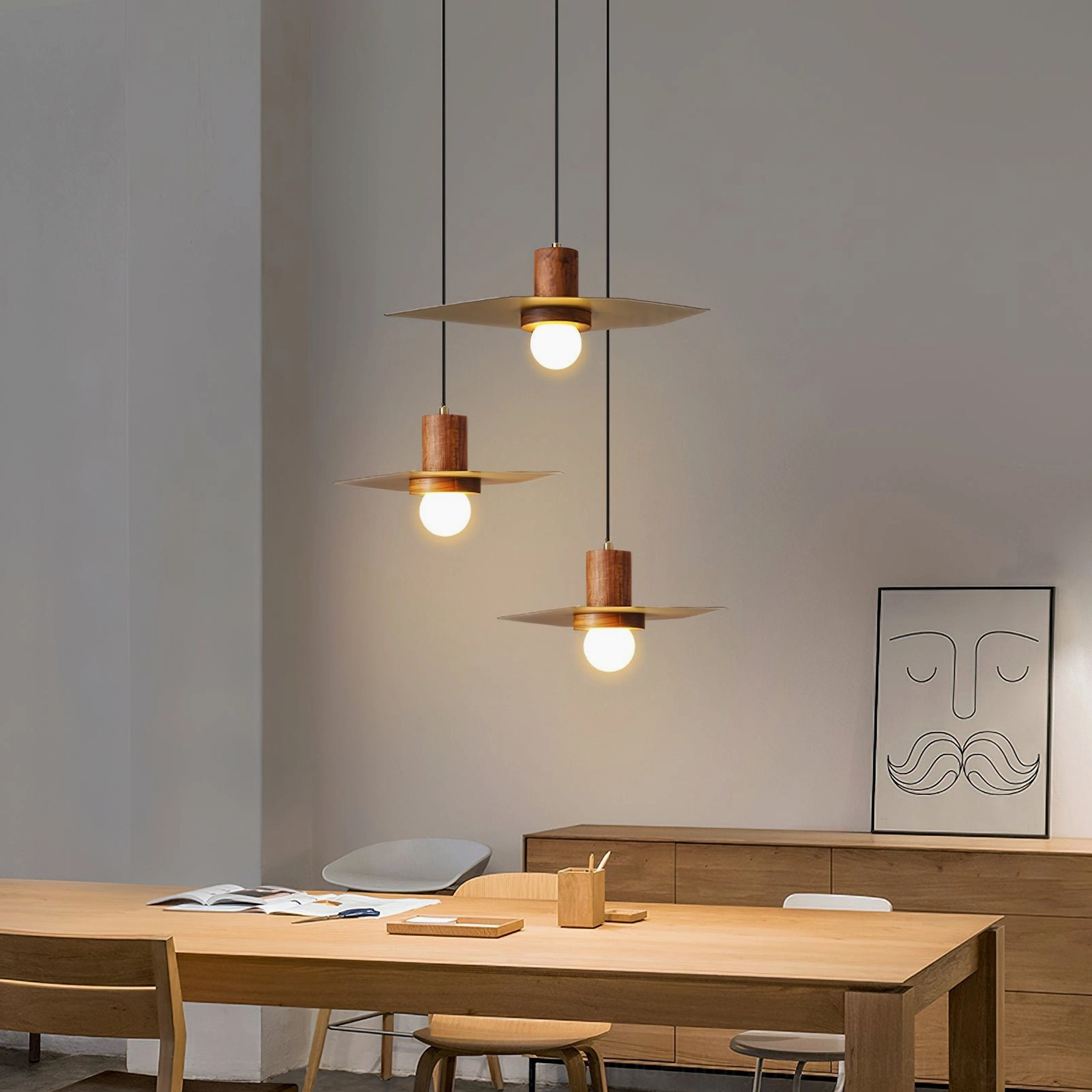 Three Elara pendant lights clustered above modern dining room table creating warm ambient lighting