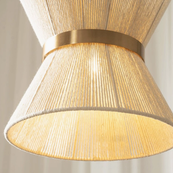 Elara hourglass woven pendant light illuminated from below, revealing warm amber glow through cotton woven shade and visible handwoven texture