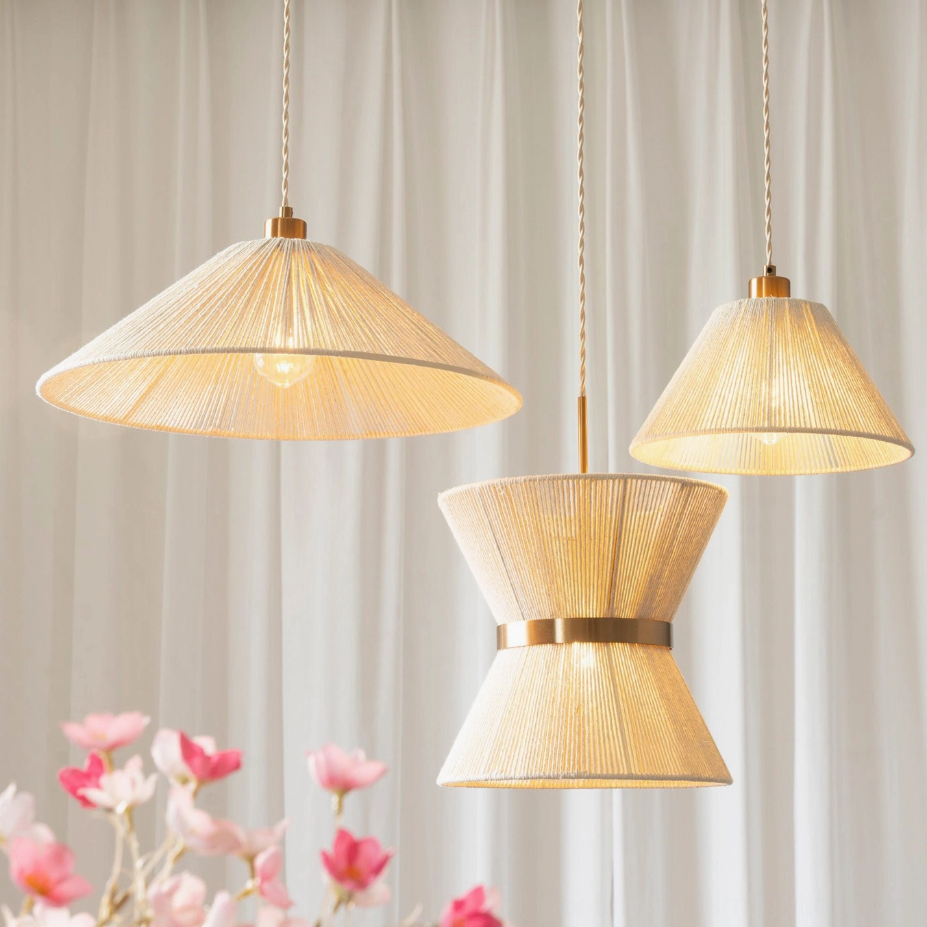 Assorted Elara woven pendant lights in multiple sizes arranged together, showcasing hourglass and conical shapes with warm beige tones and gold finishes in interior setting