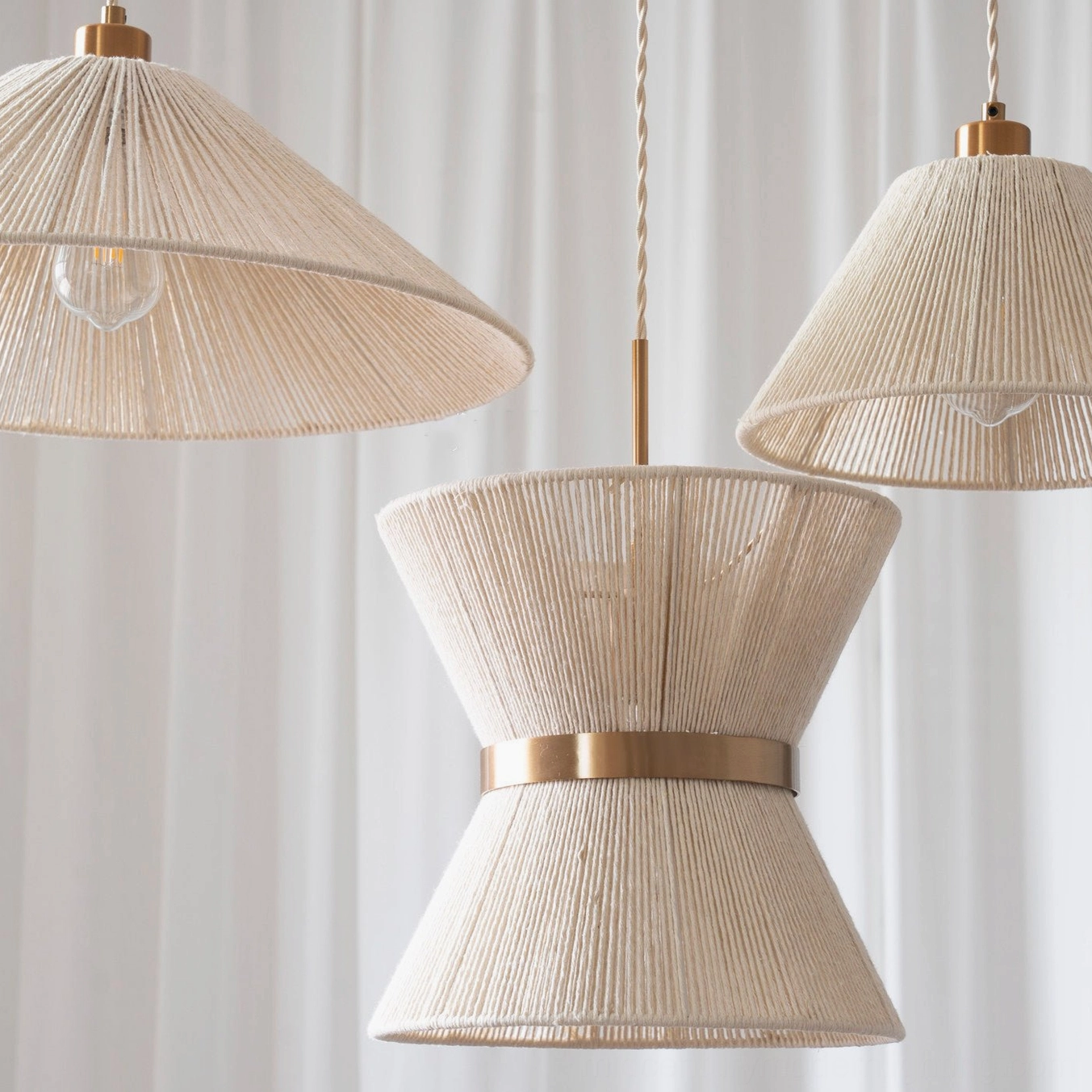 Multiple Elara woven pendant lights in different models displaying sculptural hourglass and conical silhouettes with bohemian aesthetic