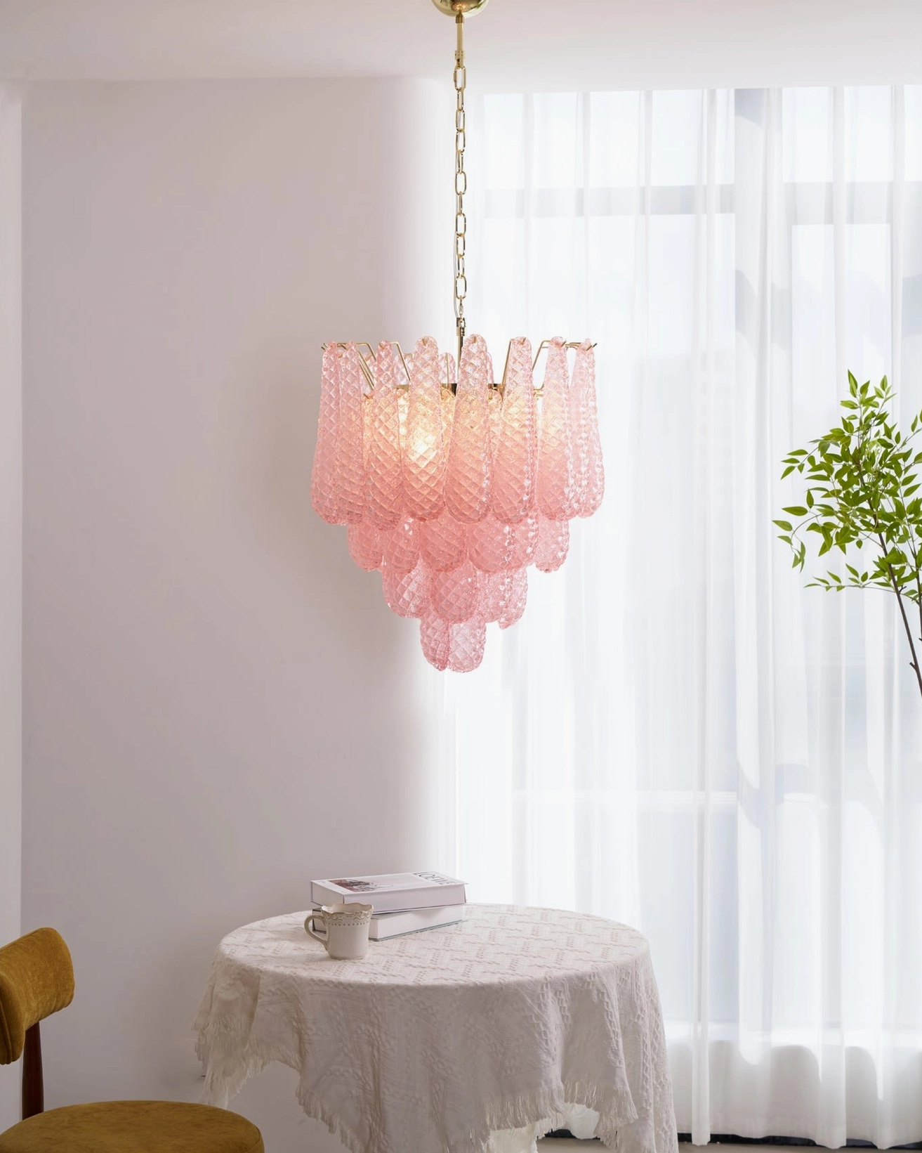 Elegant pink tiered glass chandelier product display with golden metal accents