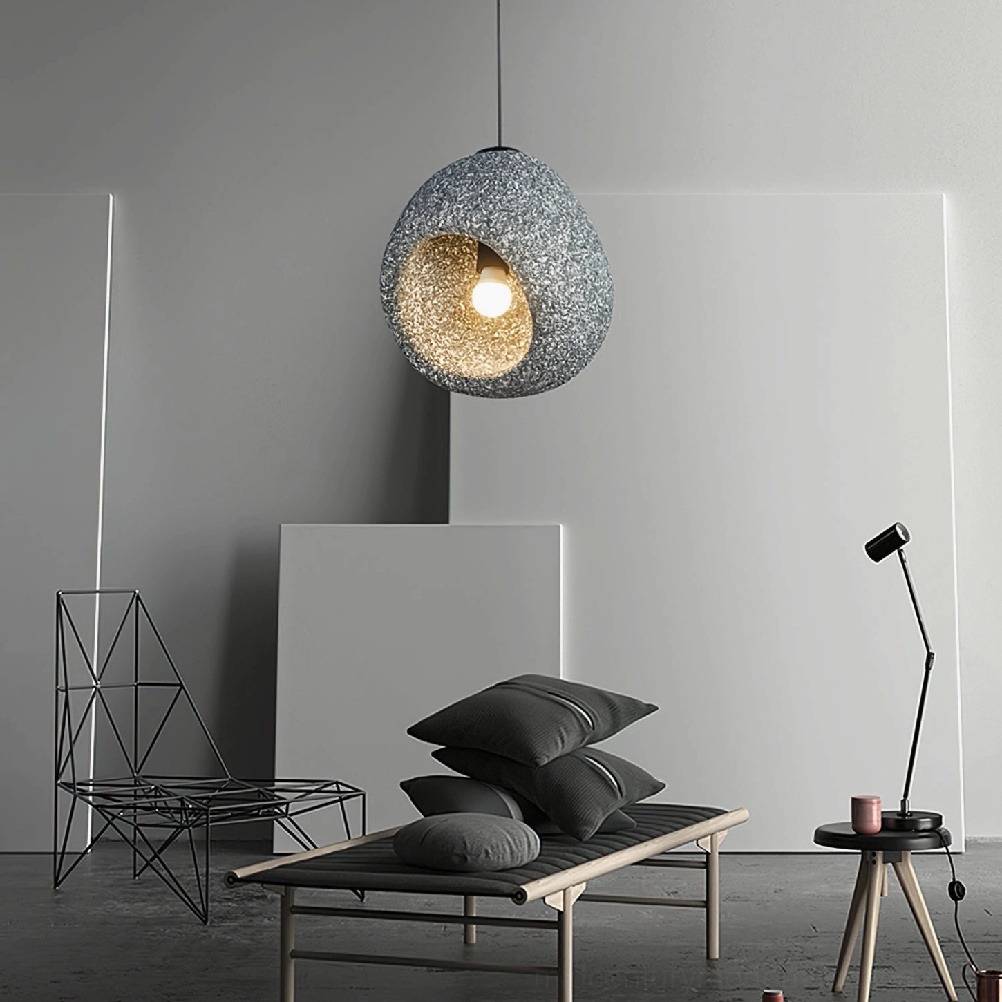 Dark speckled stone Elian pendant lamp three-quarter view in modern resting space with warm internal glow