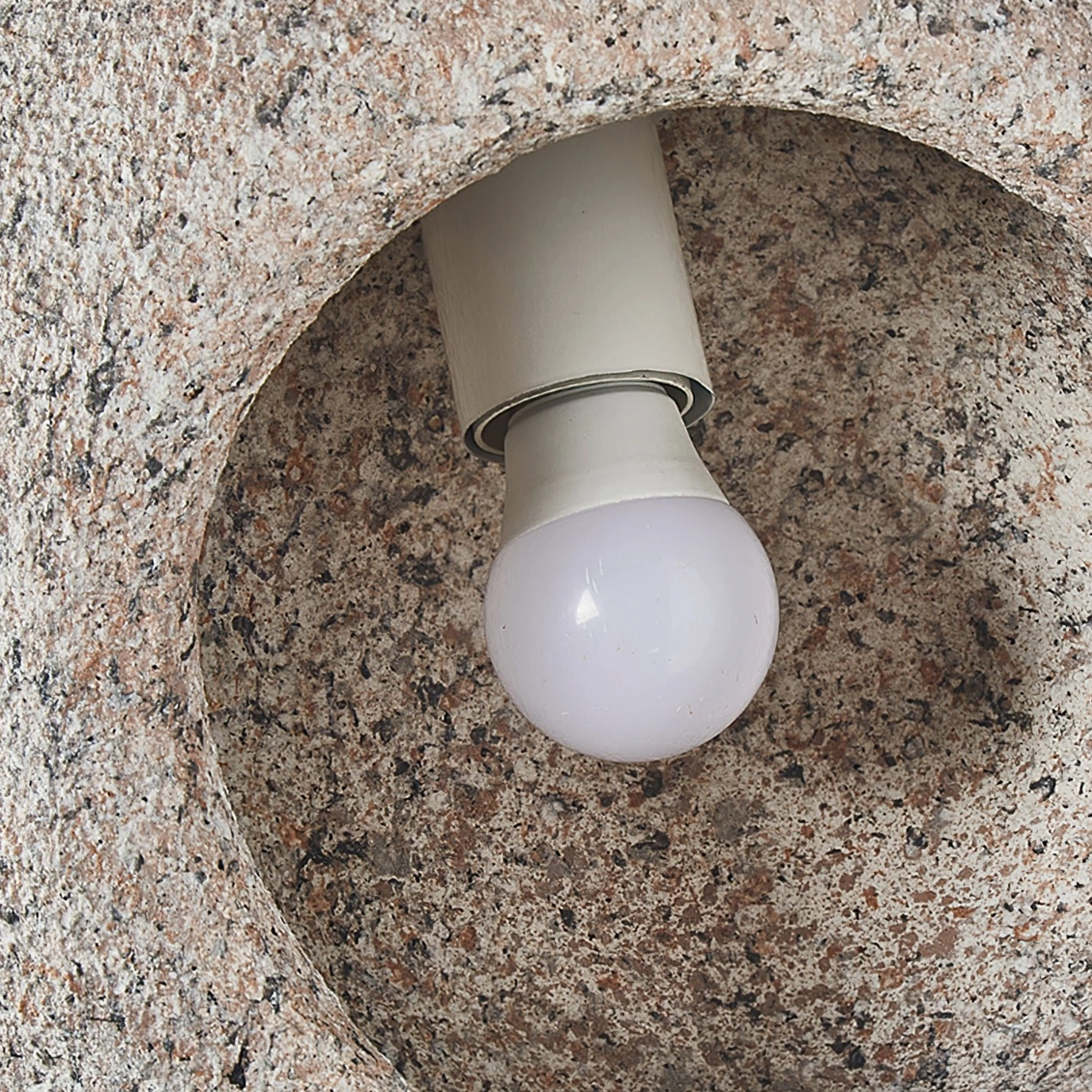 Interior macro close-up detail of Elian pendant lamp showing LED bulb and porous rough texture