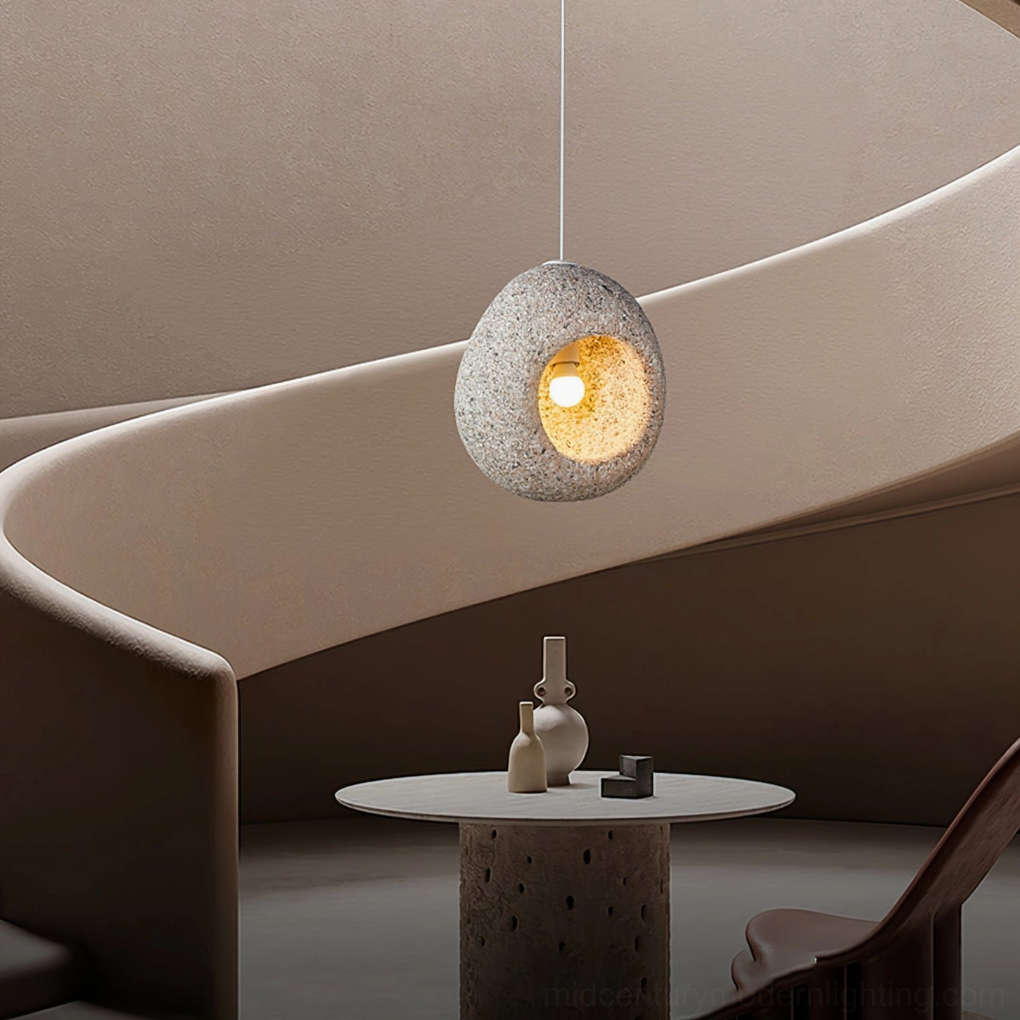 Single Elian stone pendant lamp suspended above luxury minimalist curved sofa in lounge area