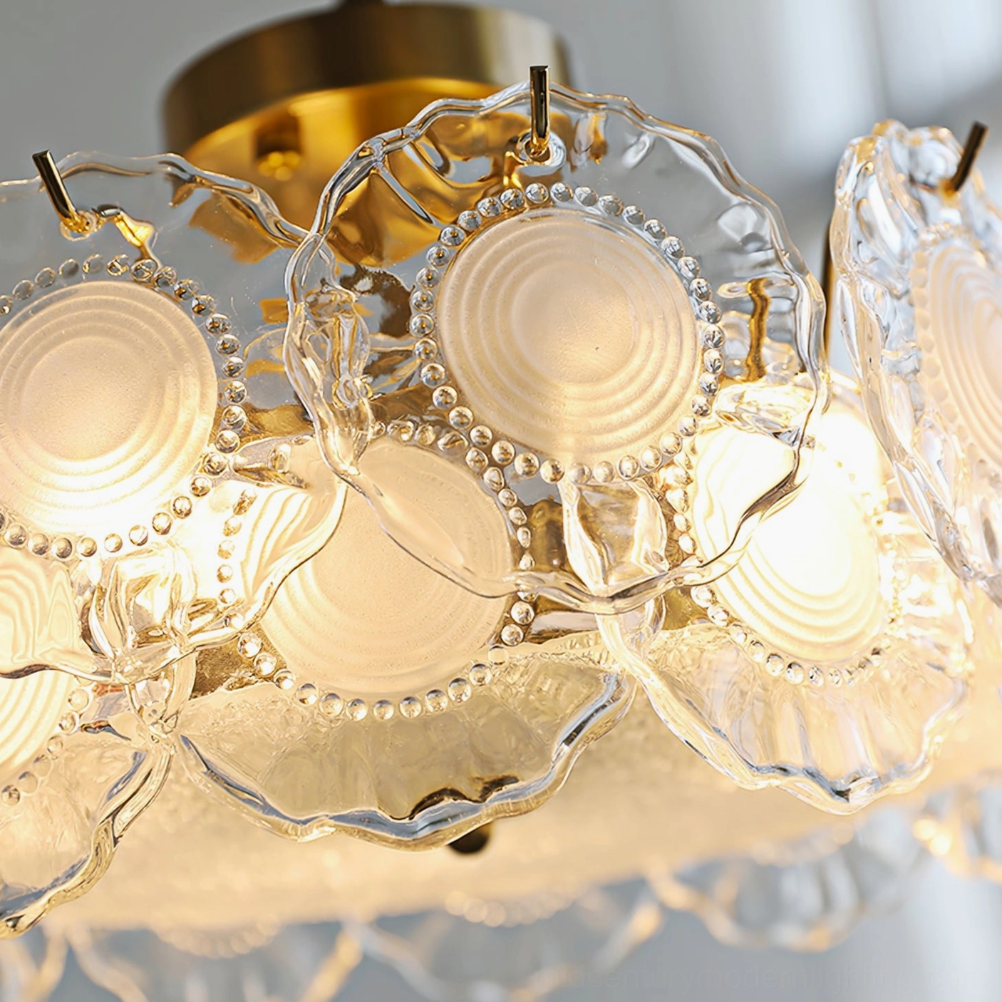 Extreme close-up of ripple embossed glass shade with beaded brass metal frame detail