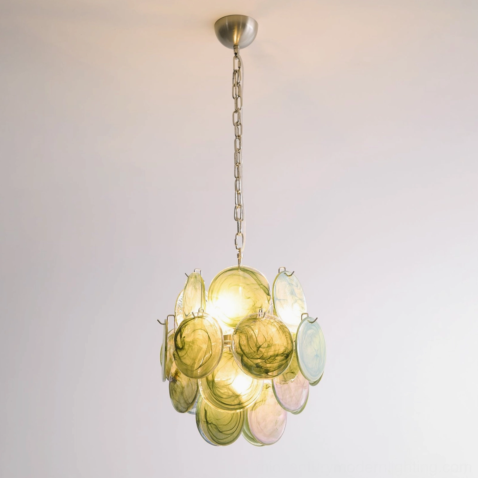 Illuminated emerald disc chandelier warm yellow-green glow marbled glass warm lighting