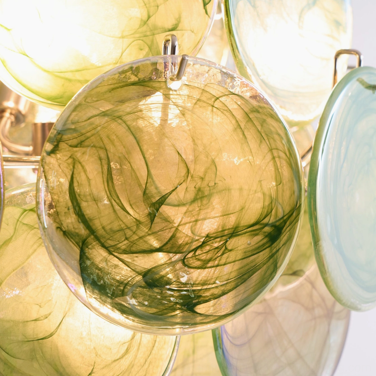 Macro close-up of swirled emerald glass patterns inside disc chandelier handcrafted detail