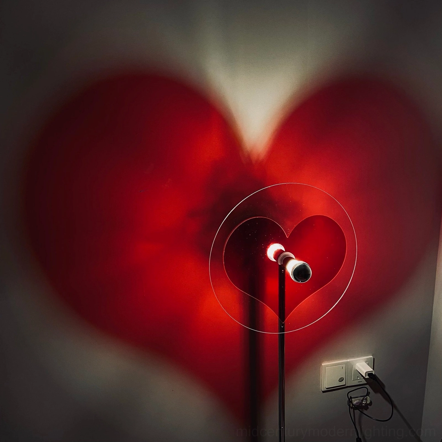 Red heart floor lamp creating emotional connection through atmospheric light design and projection