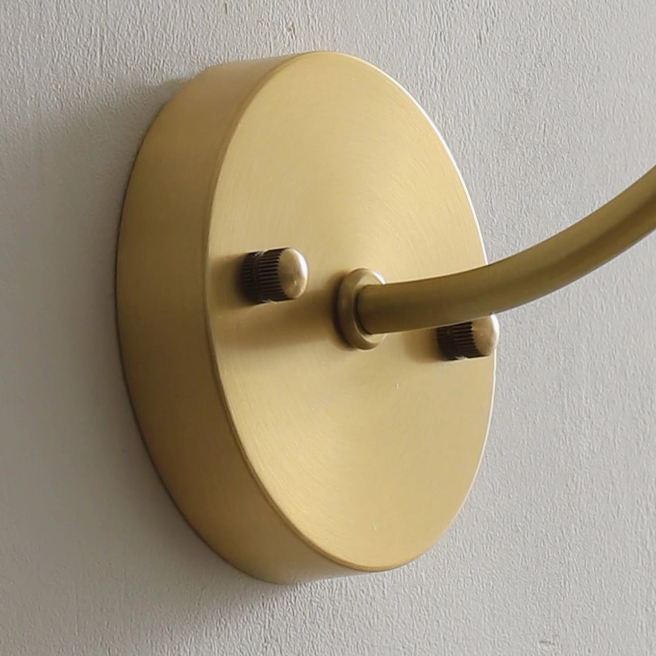 Ercole mounting base close-up showing brushed gold circular metal plate and adjustable joint