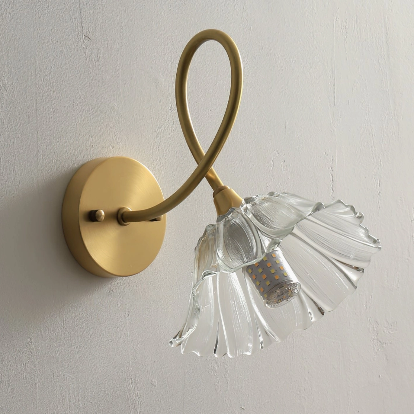 Ercole floral sconce unlit showing twisted brass arm and detailed fluted glass shade structure