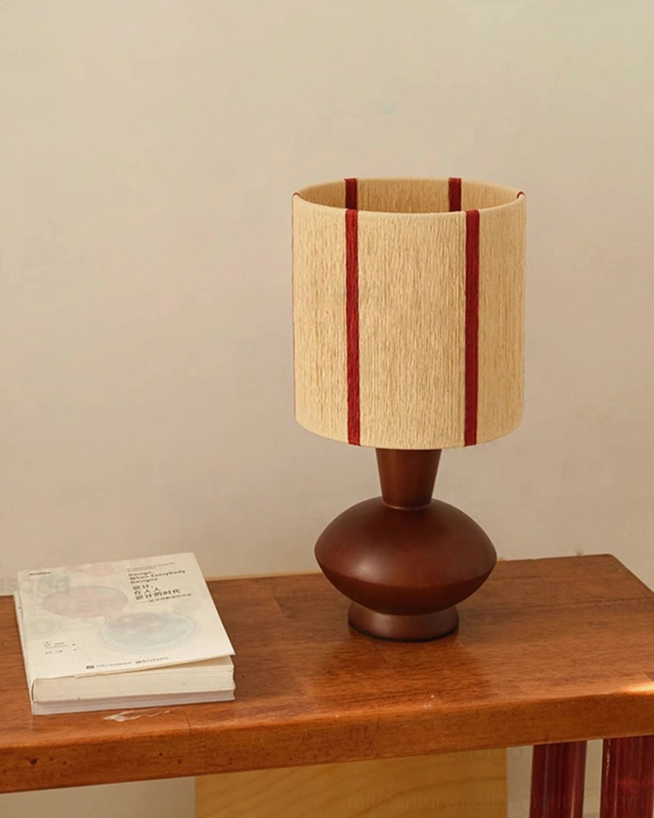 Ernest mid-century modern lamp side view on console table with stacked books creating warm home decor ambiance
