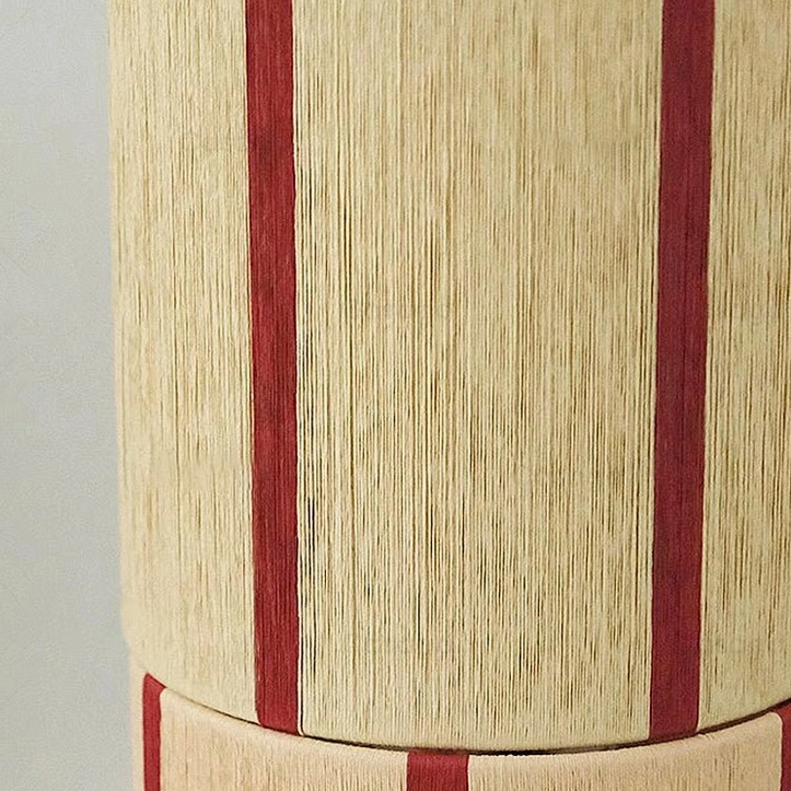 Close-up macro detail of Ernest lamp shade showing hand-applied red vertical stripes on natural woven beige linen