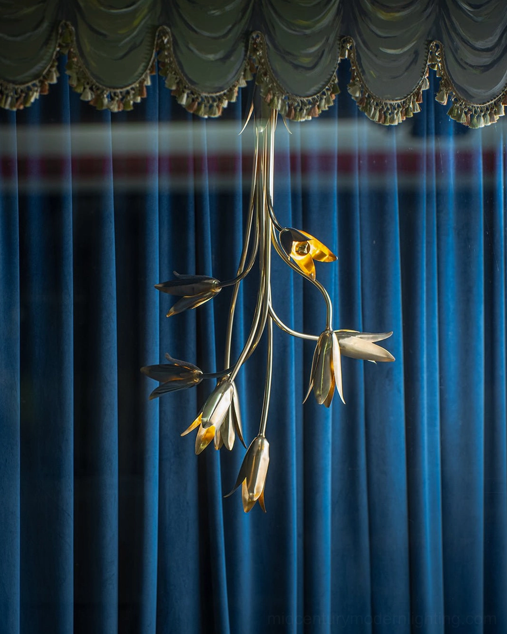 Evadne brass tulip chandelier hanging in luxury interior with navy velvet curtains and ornate valance