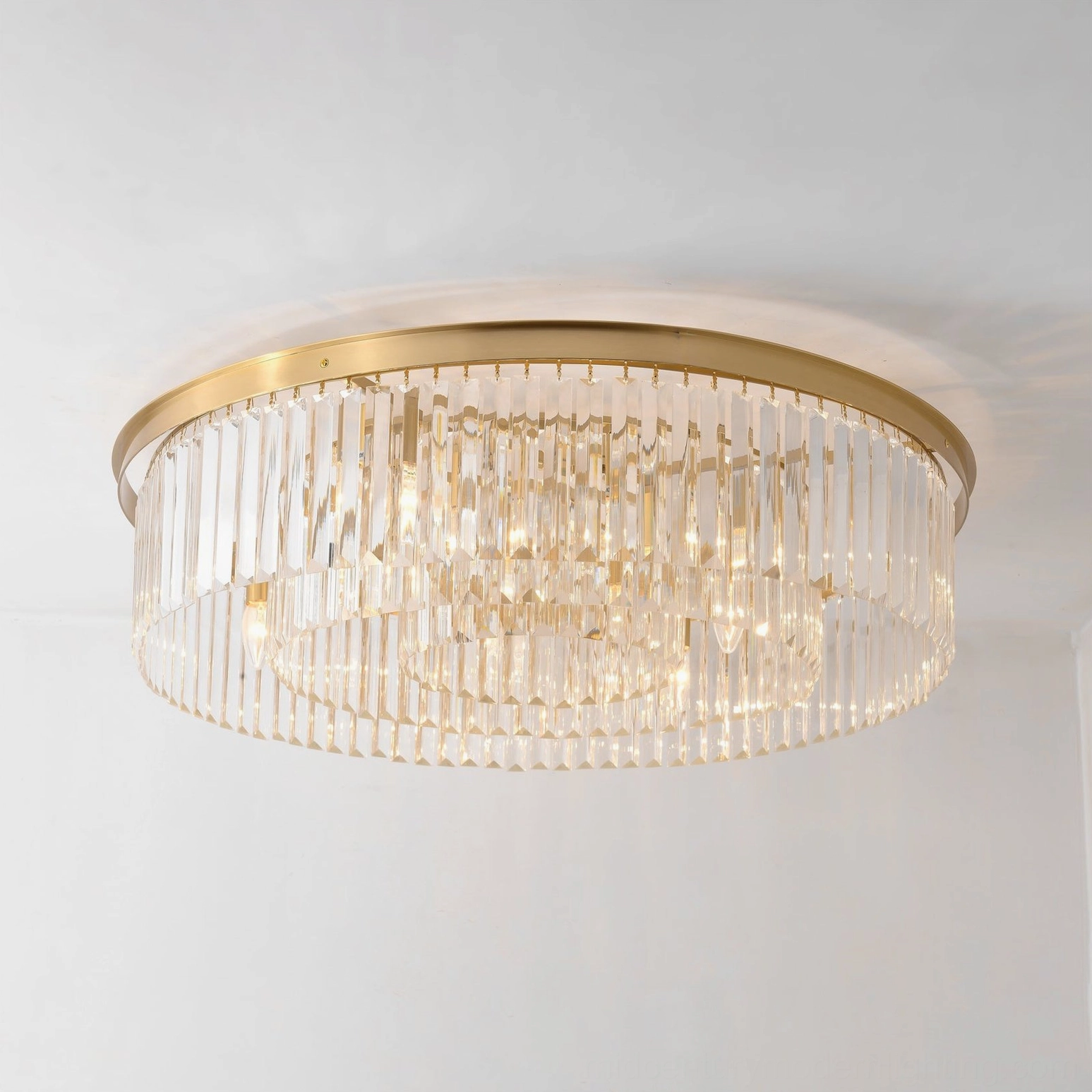 Evina crystal ceiling light illuminated showing sparkling faceted crystal rods with warm brass frame