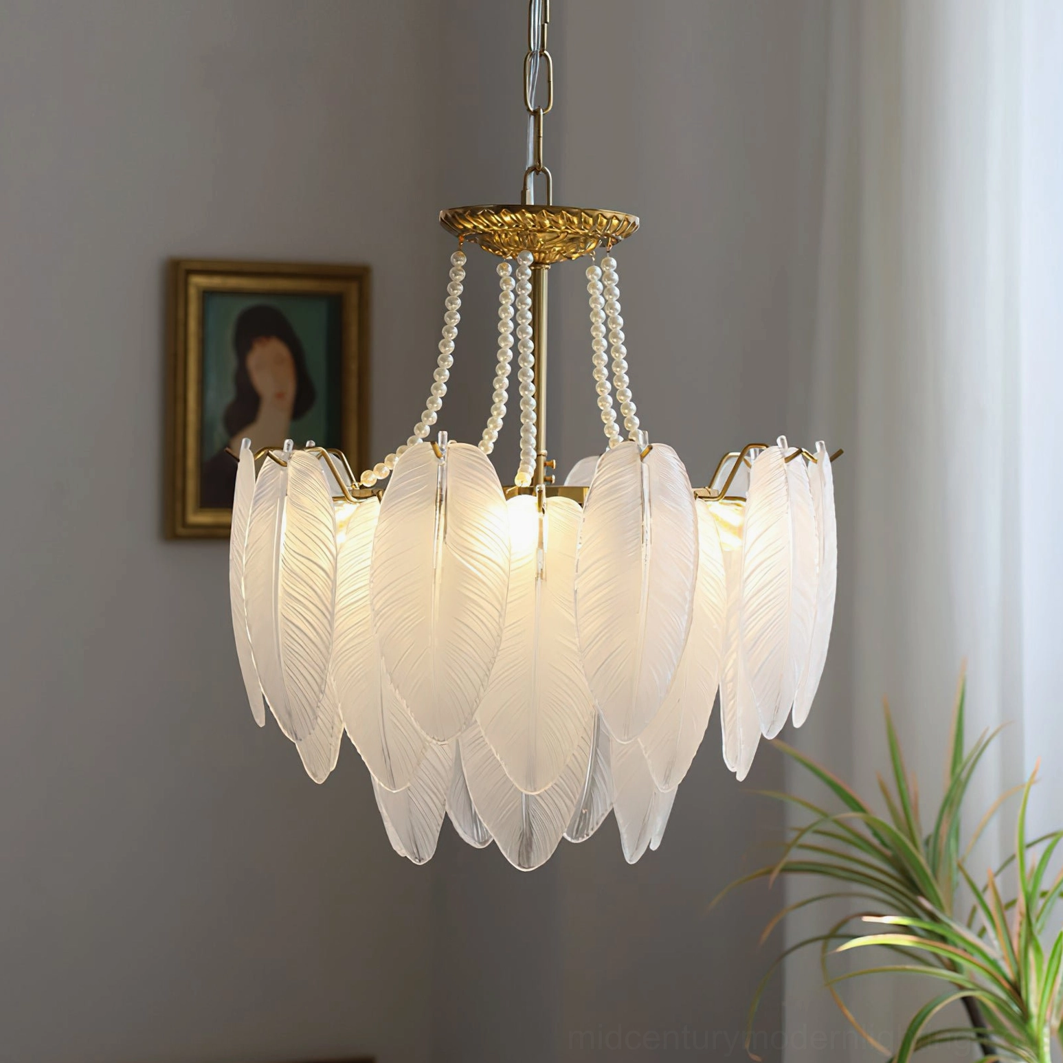 Illuminated feathered glass chandelier casting warm ambient light through frosted white glass shades in home interior with sheer curtains, portrait wall art, and green plants