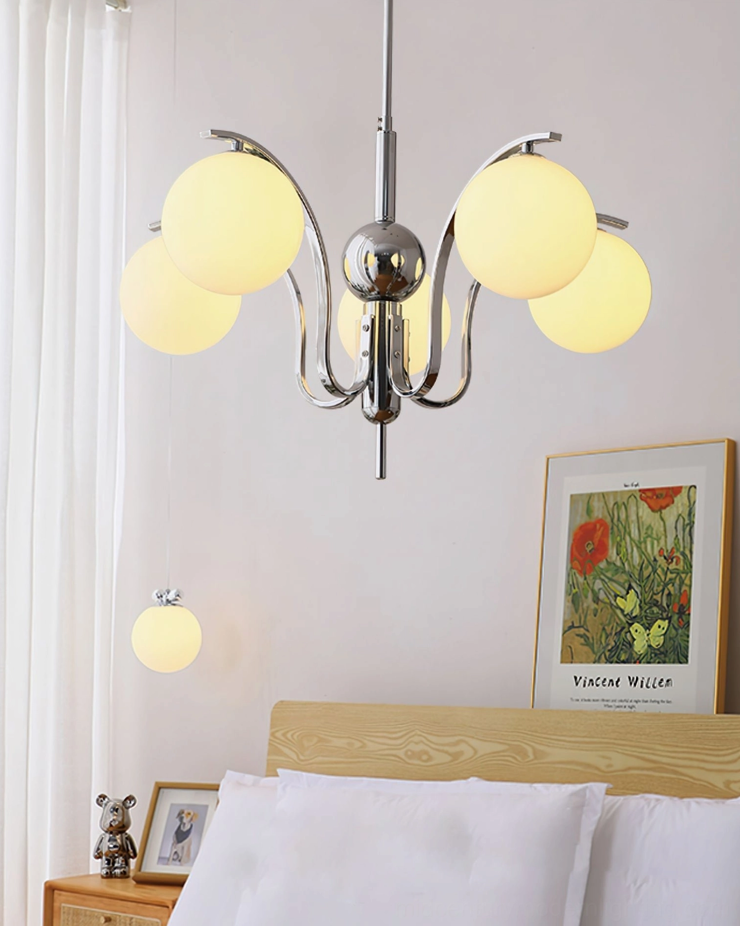 5-head yellow glass globe chandelier with lit warm shades and chrome frame installed above bed