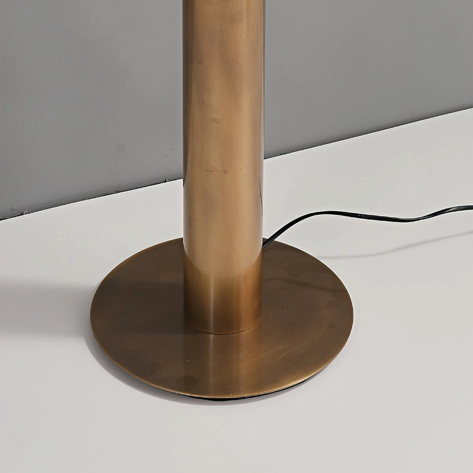 Close-up top-down detail of floor lamp base showing brushed antique brass metal construction and finish