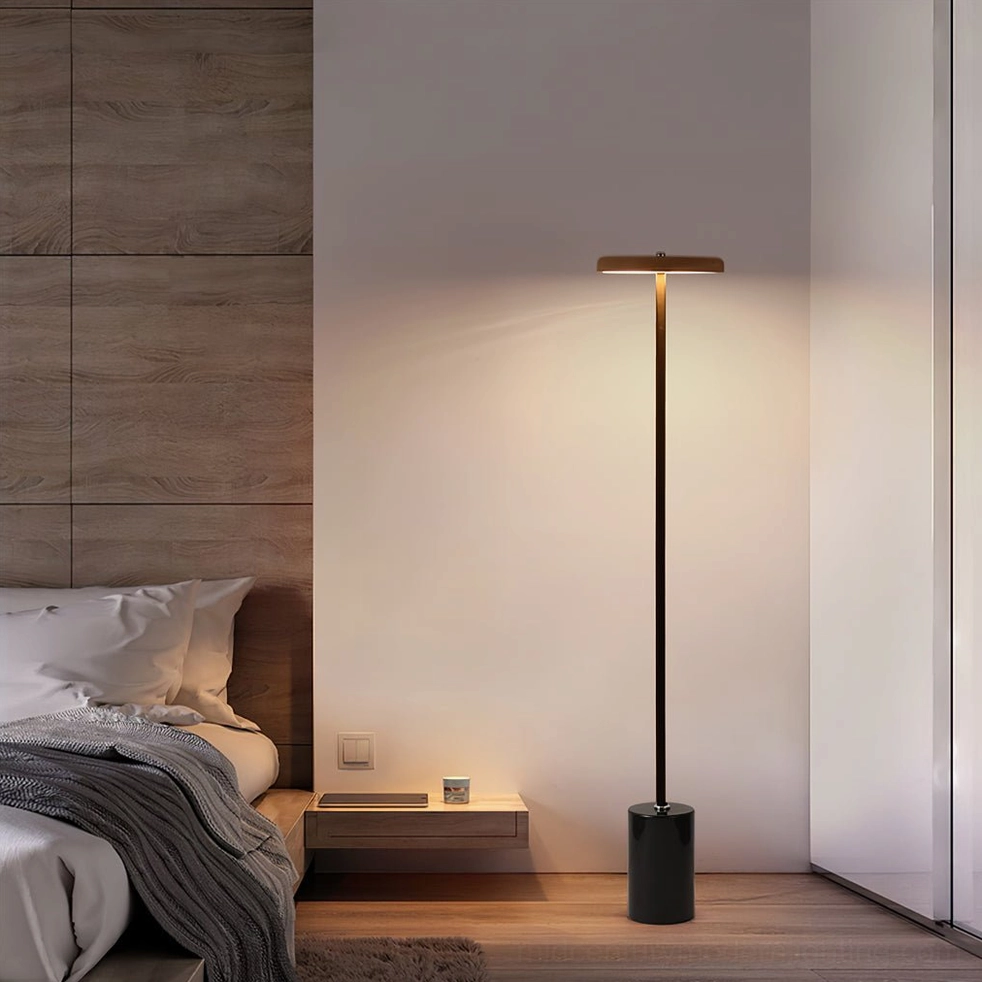 Three-color LED floor lamp in modern bedroom with wood accent wall, slim black metal pole and marble base creating elegant lighting
