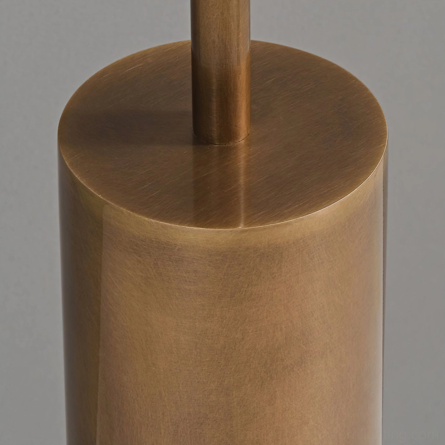 Close-up overhead view of floor lamp pole and weighted base demonstrating smooth brushed gold brass metalwork