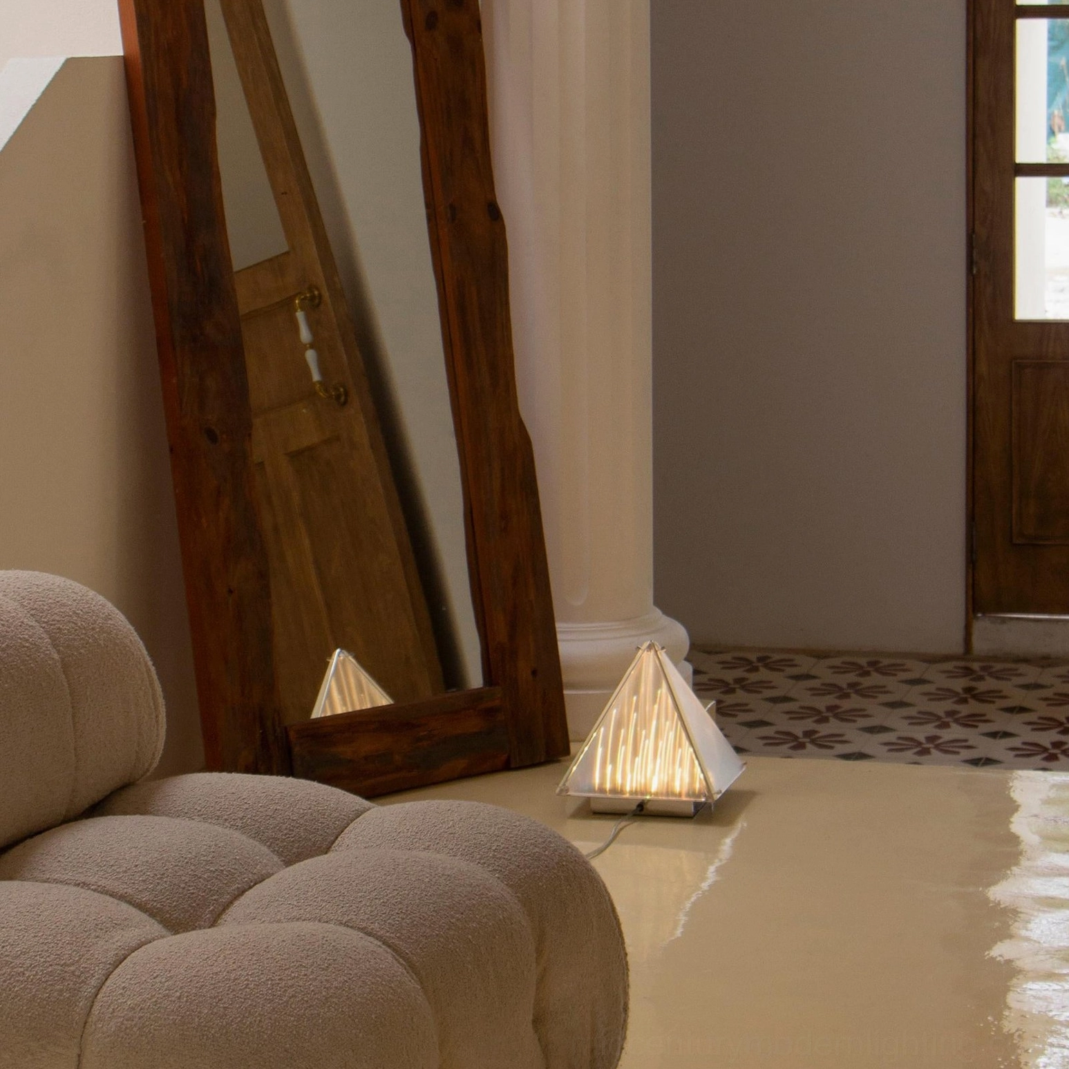 Fragment geometric pyramid lamp in entryway with large wall mirror and glossy tiled floor