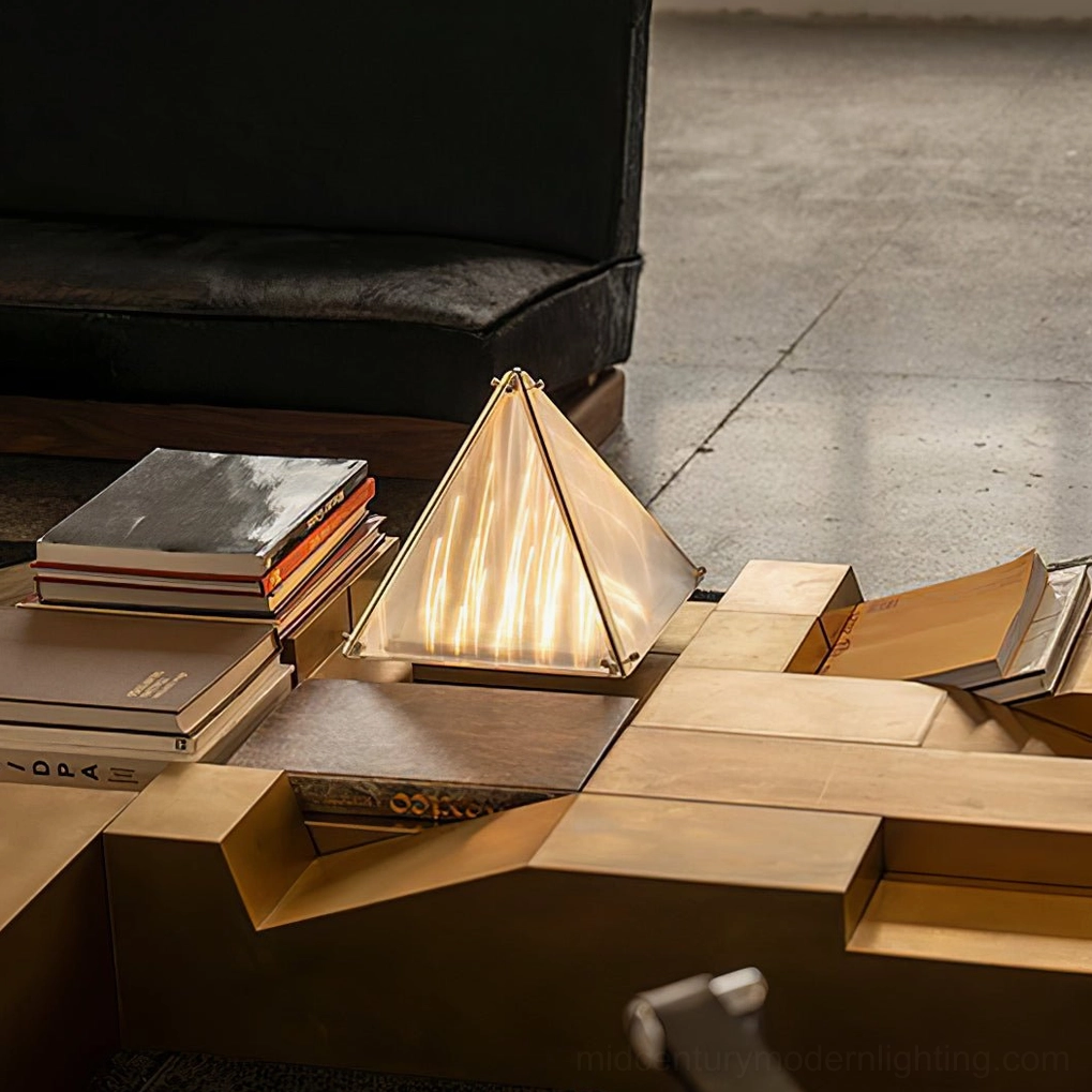 Pyramid table lamp overhead view on brass geometric coffee table with stacked books luxury setting