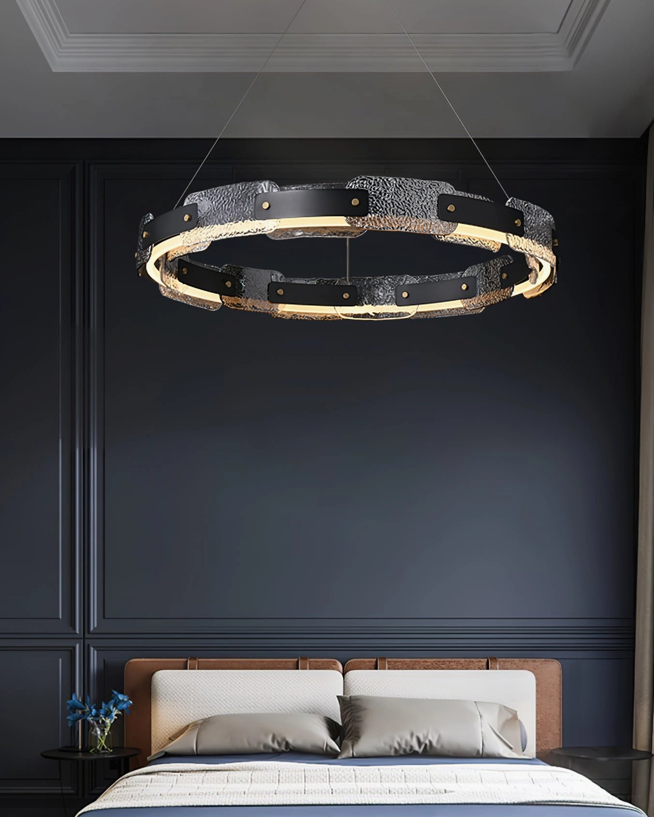 Fuze circular pendant light hanging above bed in master bedroom with dark blue accent wall, low-angle front view