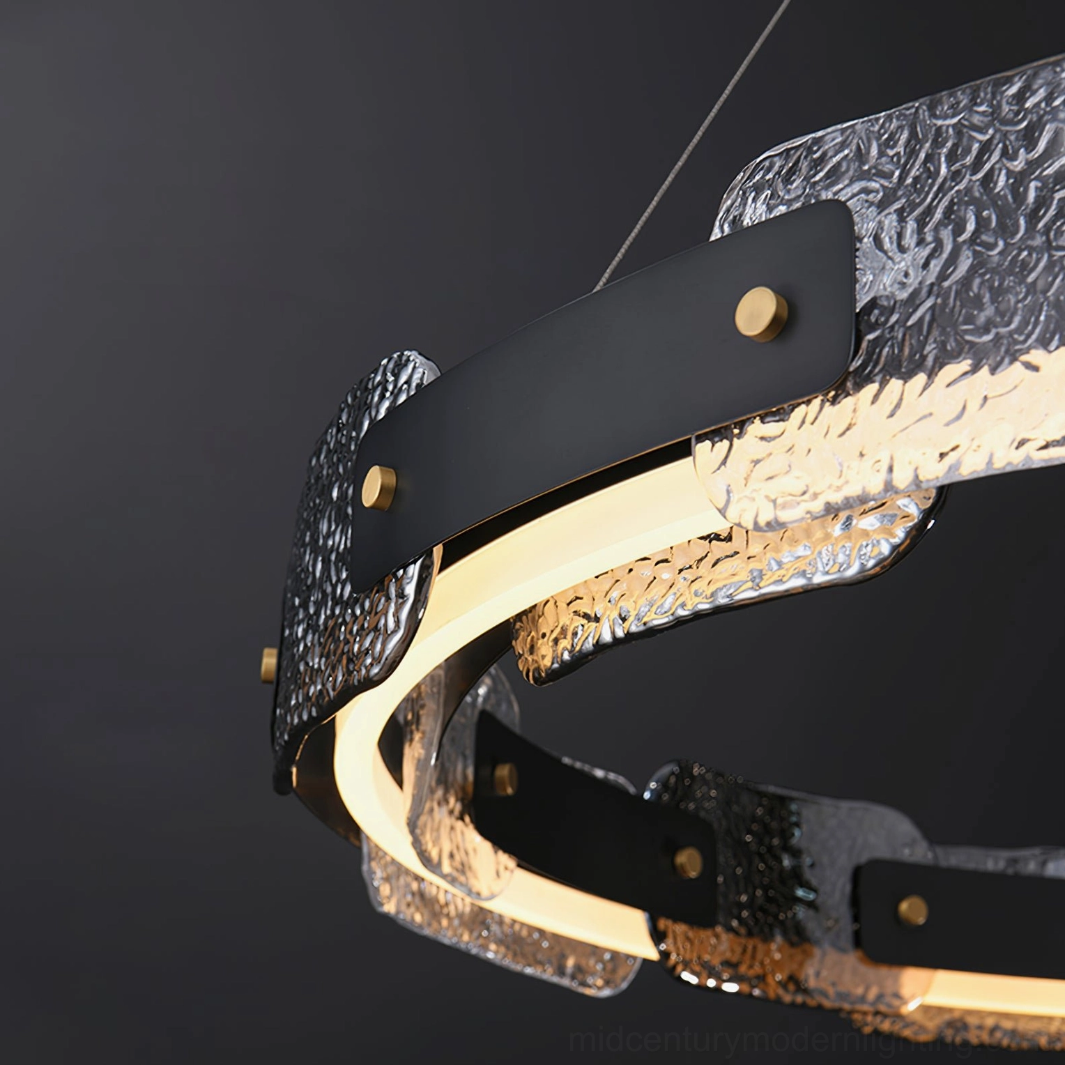 Close-up detail of Fuze chandelier showing hammered glass diffuser, black metal frame, brass fasteners and integrated LED strip