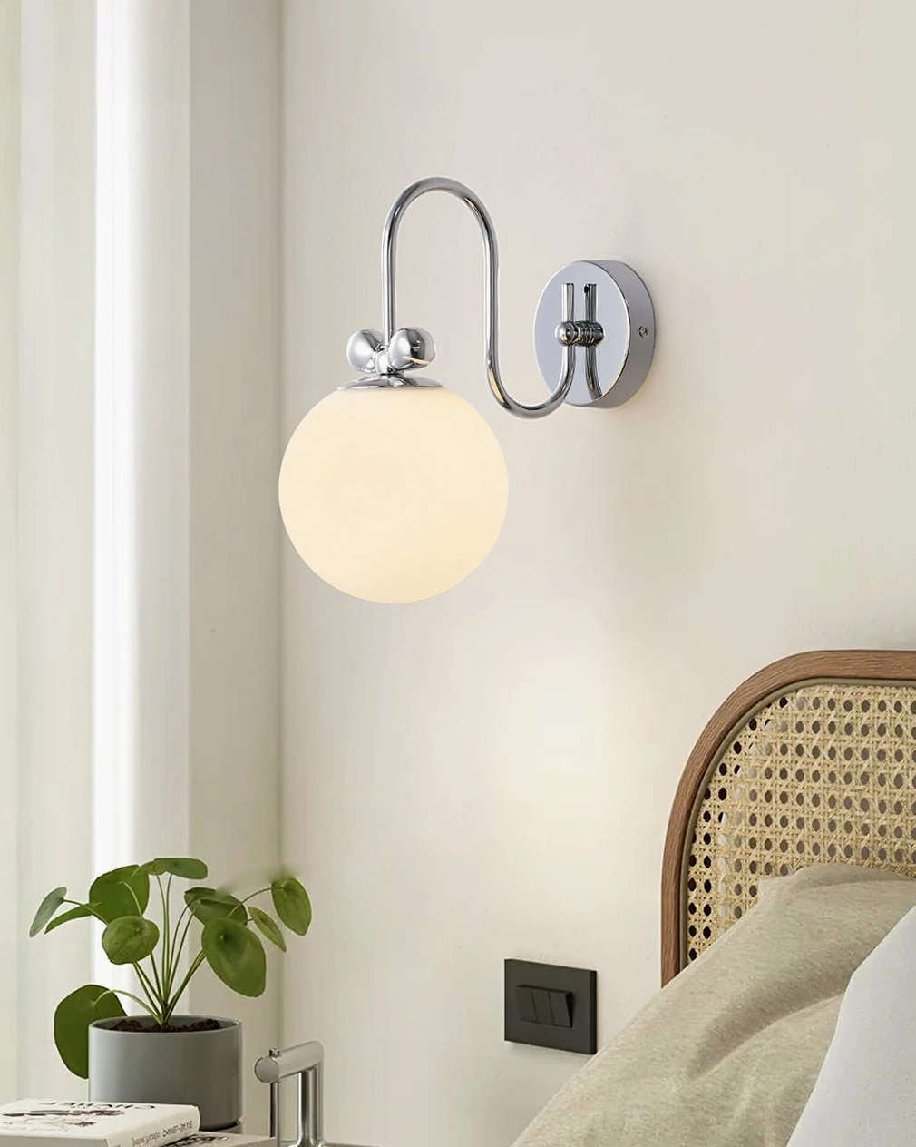 Galaxy Lux wall lamp in modern desk corner creating warm ambient glow next to minimalist cactus plant decor