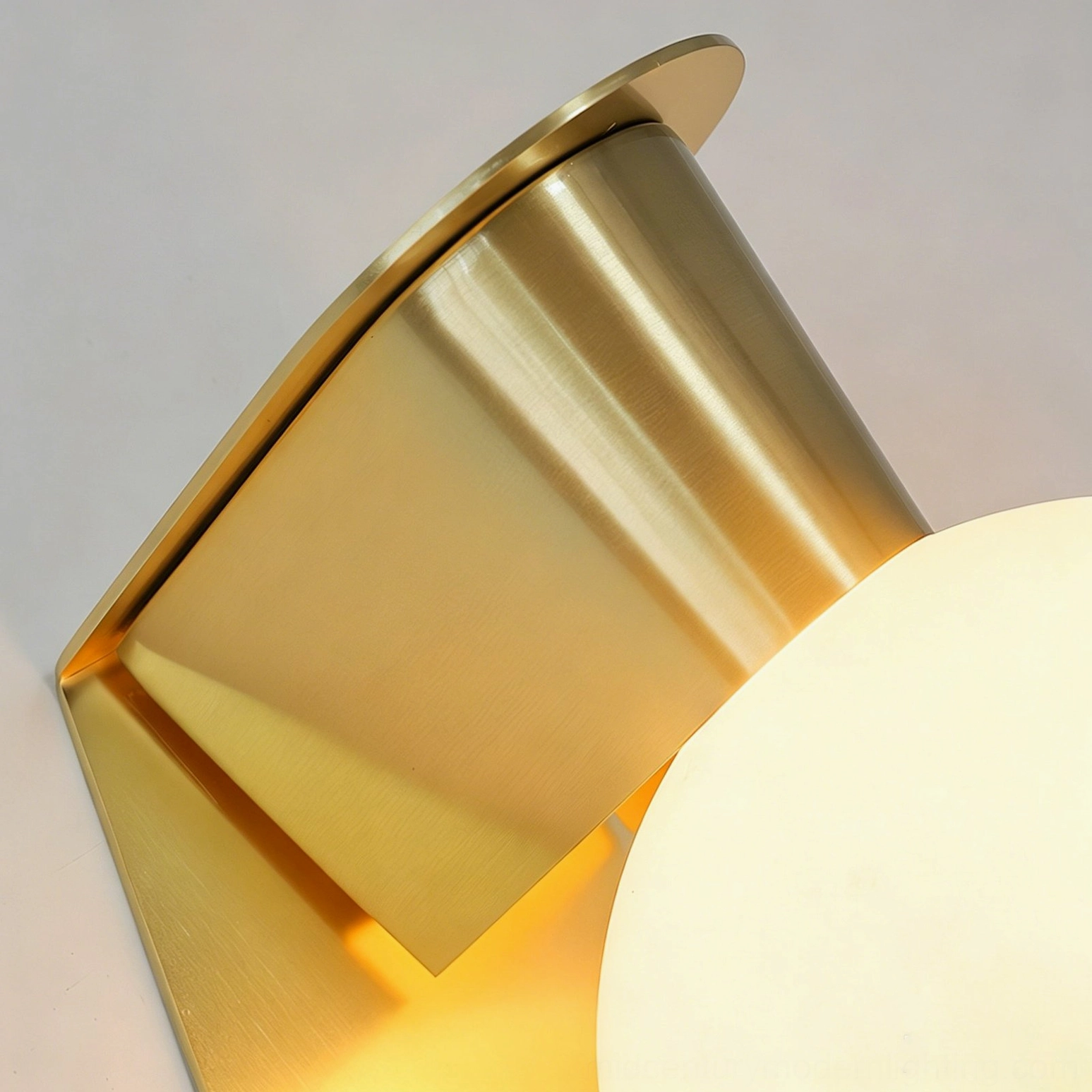 Gale Globe Wall Sconce low-angle close-up of brushed brass gold metal hardware with partial illuminated lamp view