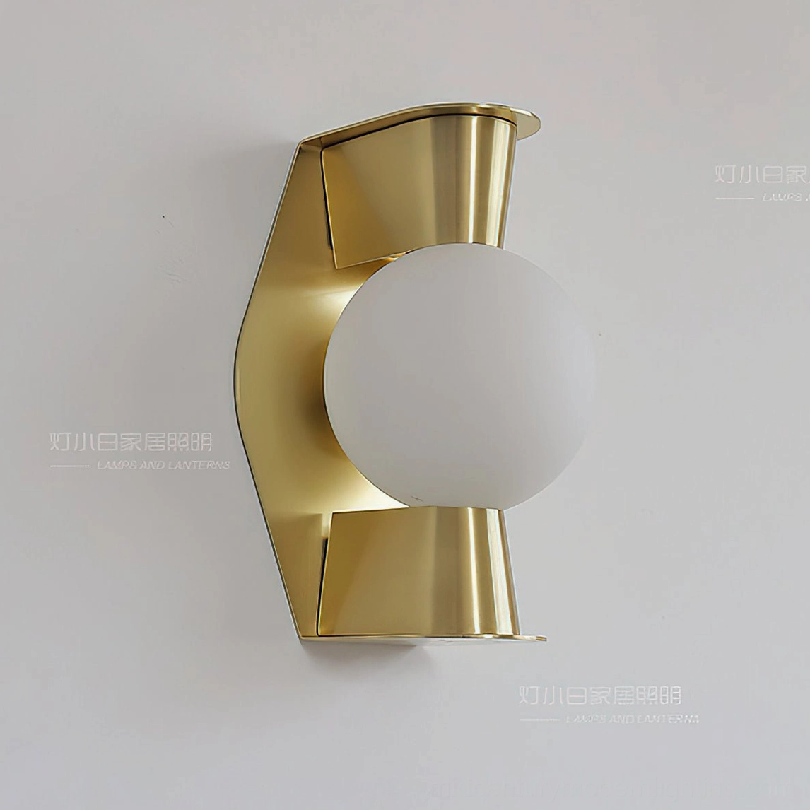 Gale Globe Wall Sconce right-angle view of unlit white frosted glass sphere with curved brass metal bracket detail