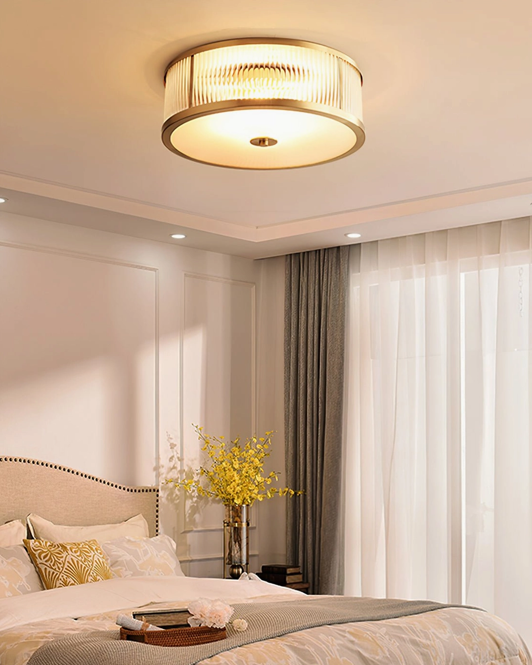 Geneva brass ceiling light in warm master bedroom with beige upholstered bed and floral decor