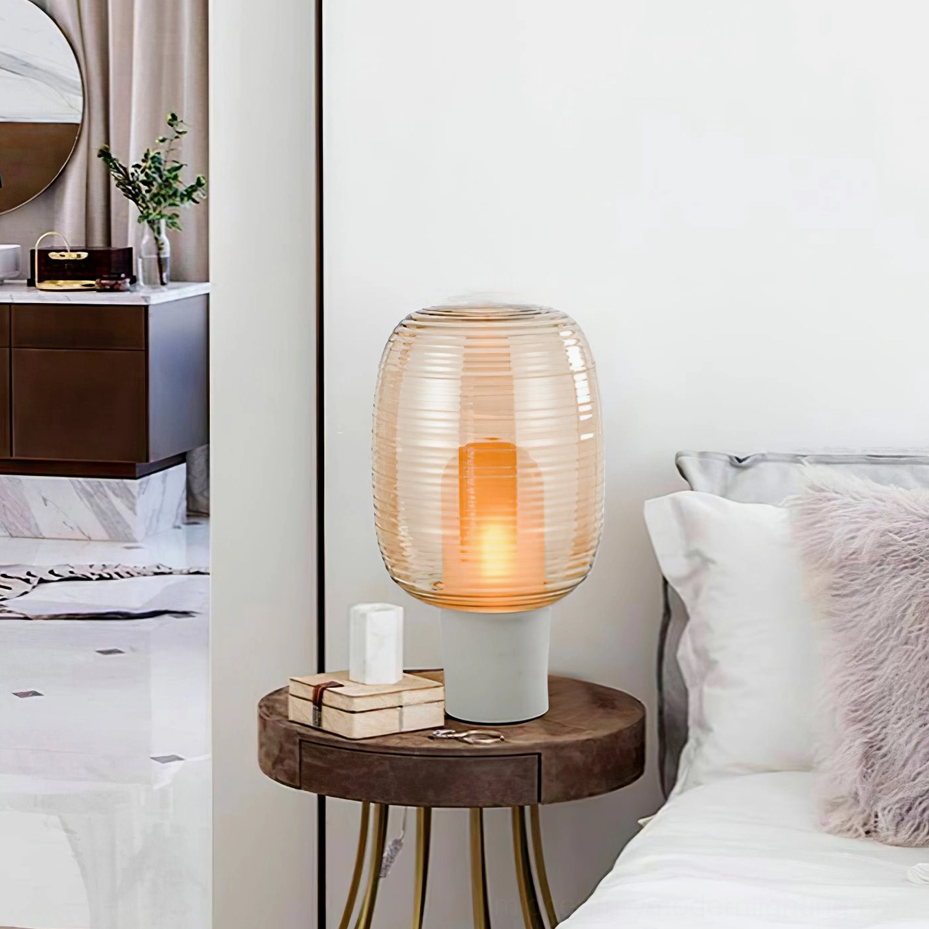 Ghia cognac amber ribbed glass lamp on wooden bedside table with stacked decor and pillows