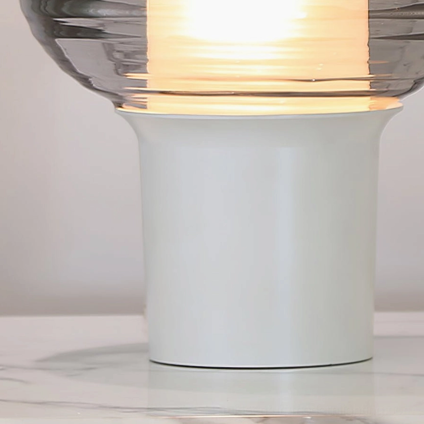 Close-up detail of Ghia table lamp base and ribbed glass shade showing craftsmanship on marble surface