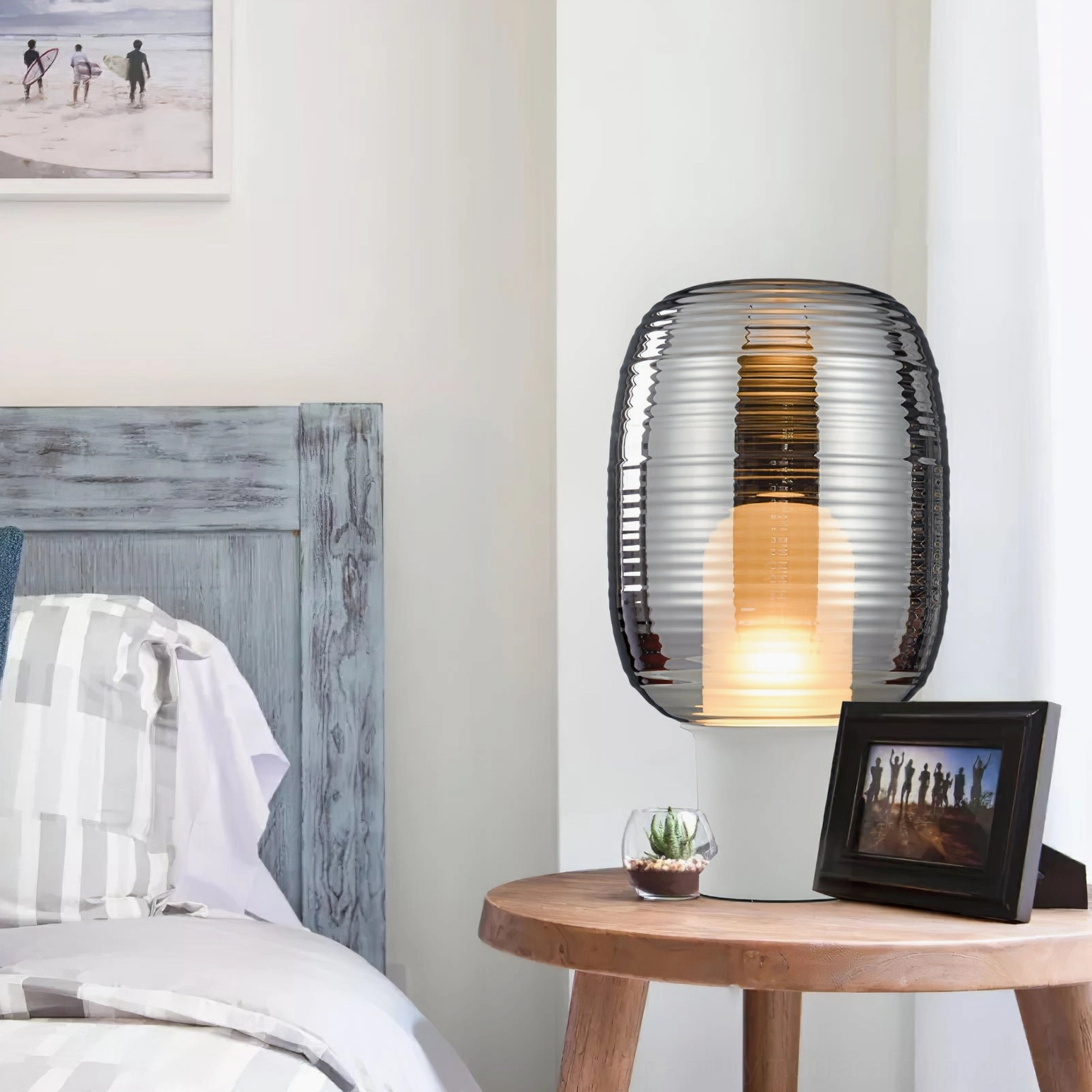 Ghia bedside table lamp with smoke grey ribbed shade on wooden nightstand in bedroom setting