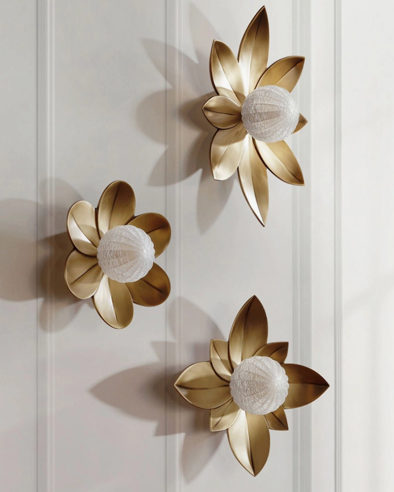 Three Gigi wall sconces in varied sizes, gradient metal finish collection display