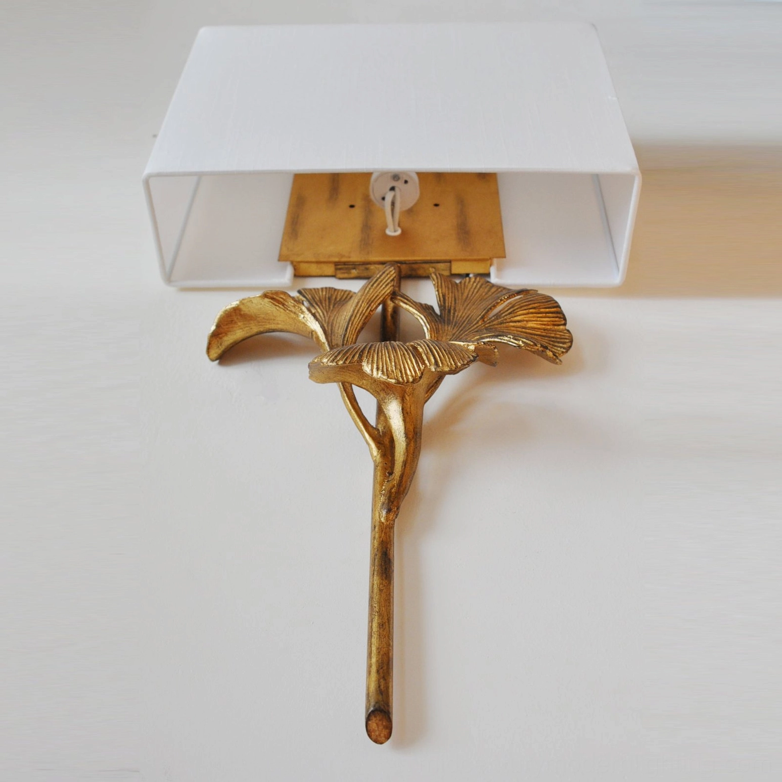 Bottom-up view of gingko wall sconce revealing rear mounting plate and metal framework