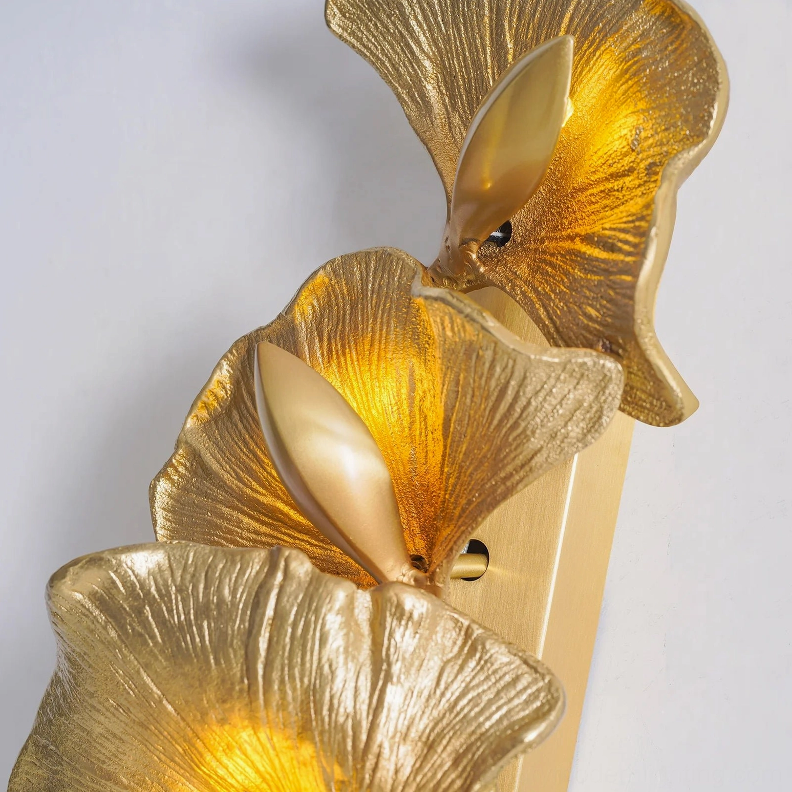 Top-down view of illuminated ginkgo leaf wall lamp showing mounting base and warm LED glow