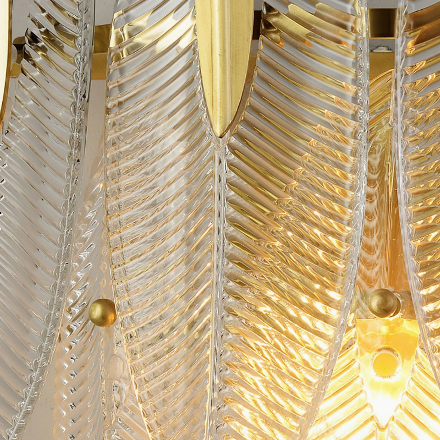 Macro close-up of Giulia brass wall lamp showing ribbed glass texture and gold metal mounting details
