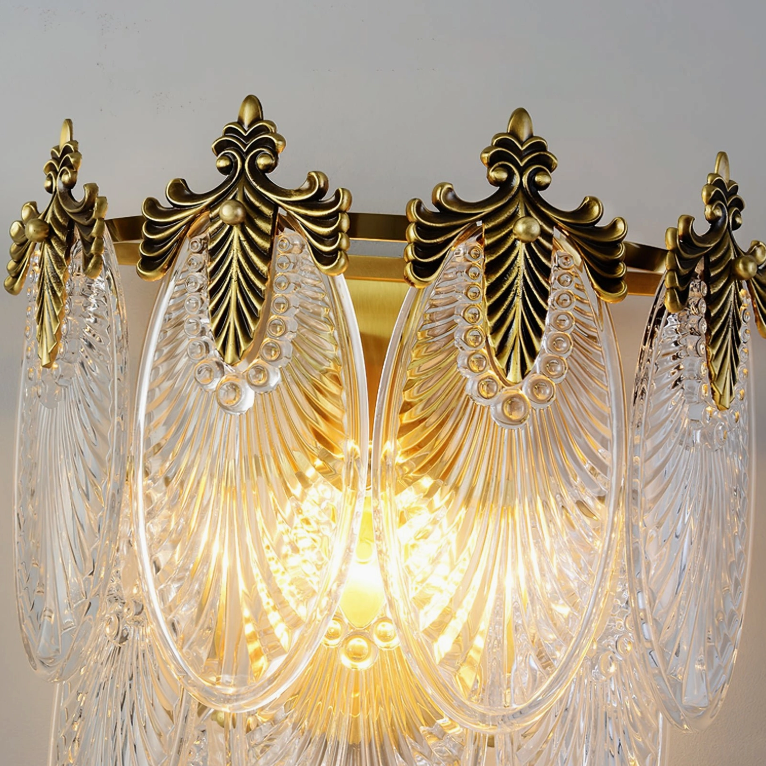 Giulia brass wall lamp three-quarter view showing sculptural glass form and metal framework elegance