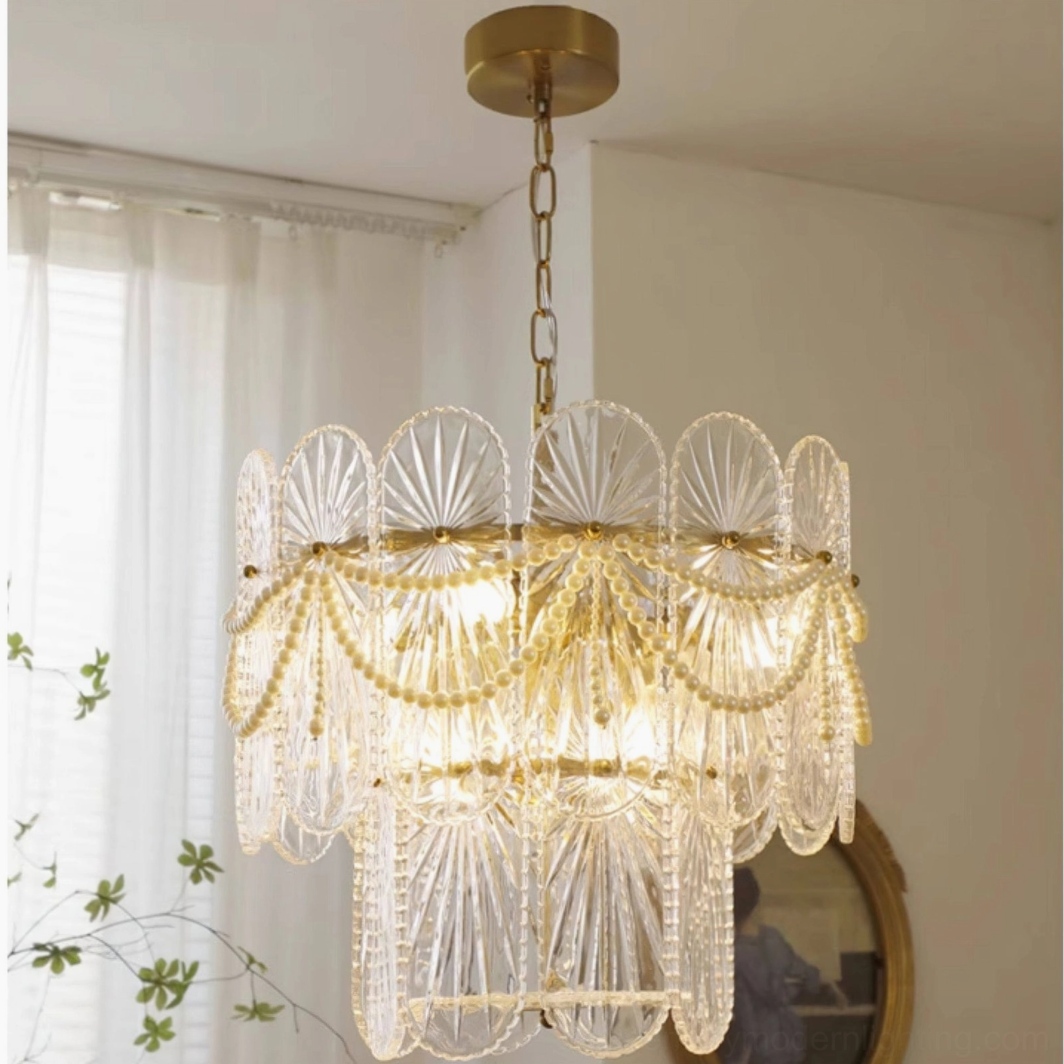 Vintage-inspired glass chandelier with ribbed panels and pearl beads installed in residential living room with natural light