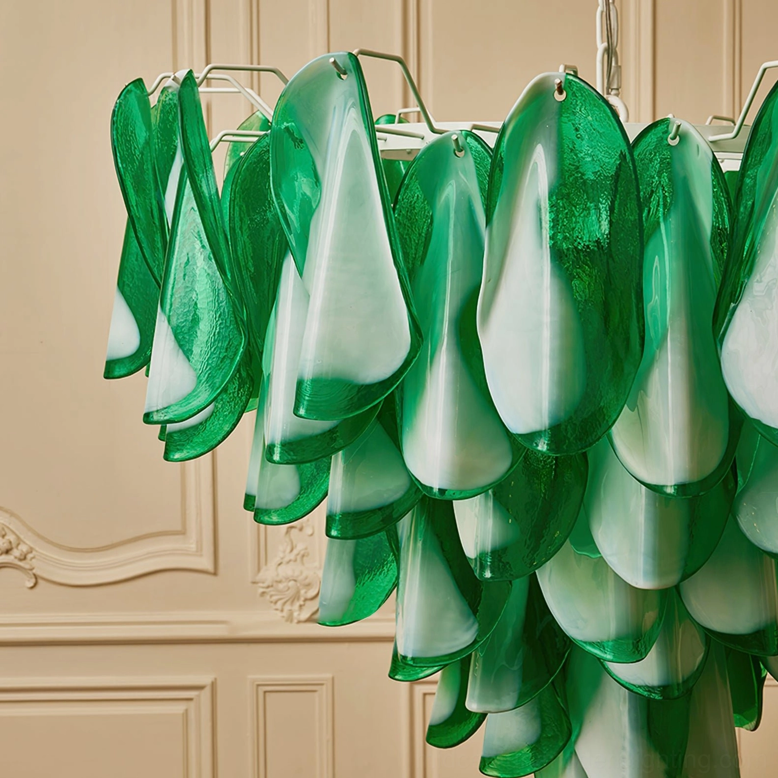 Partial chandelier view from low angle showing curved petal glass pieces, green-white color gradient and vintage interior backdrop